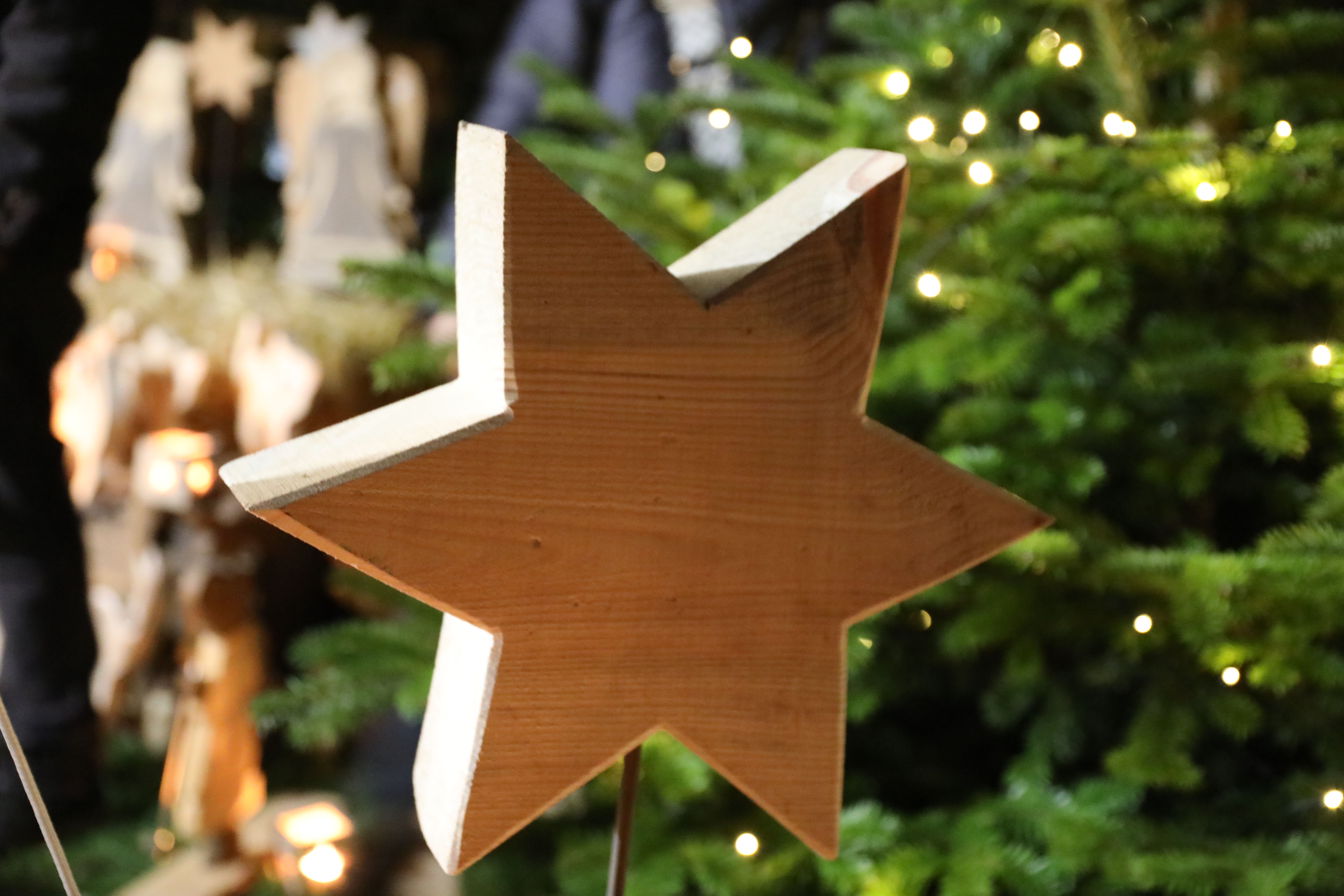 A wooden star stands in front of the Christmas market at Eulenbroich Castle.