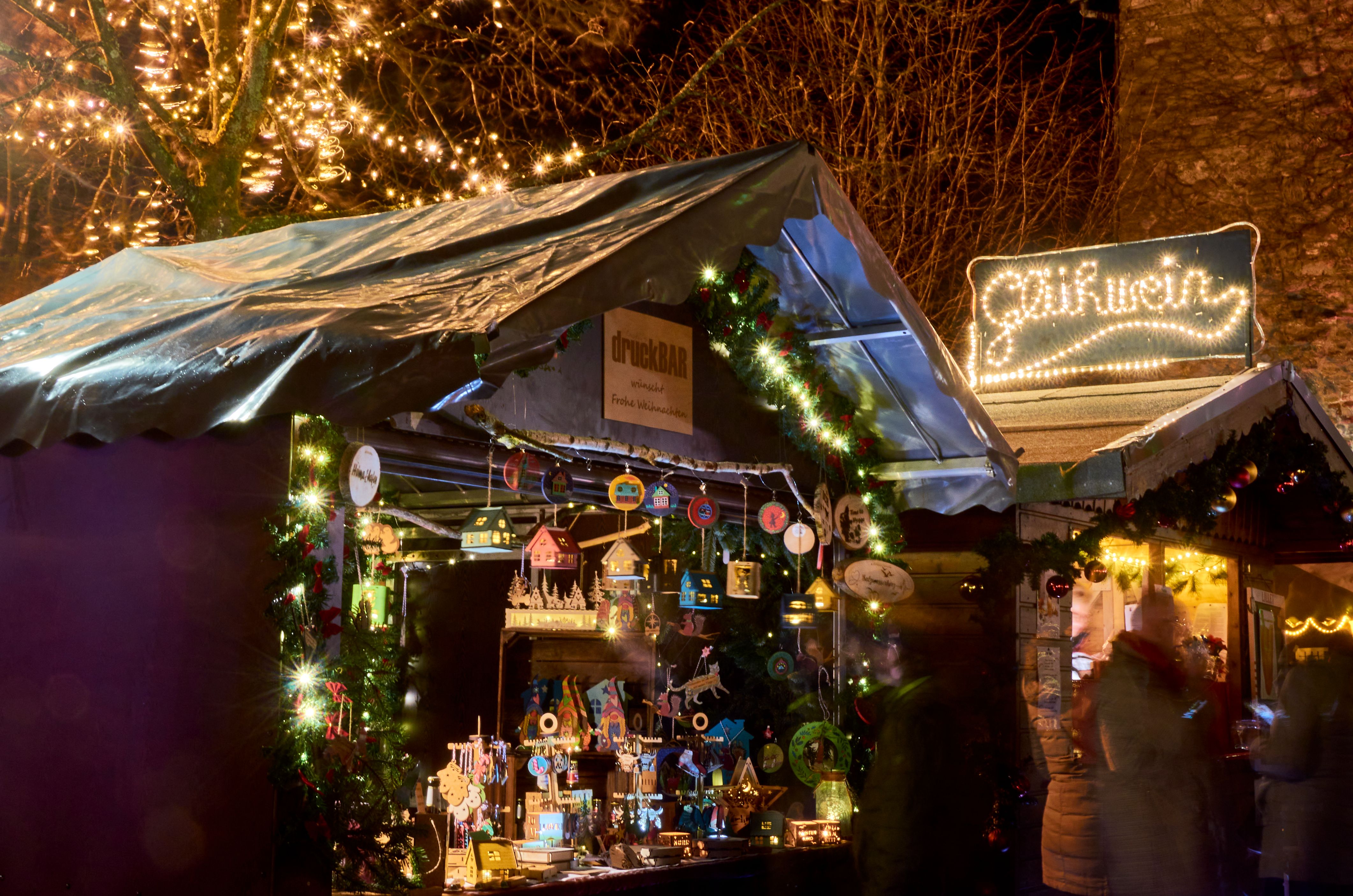 A festively illuminated stand at the Christmas market in Kürten, decorated with lights and Christmas decorations.