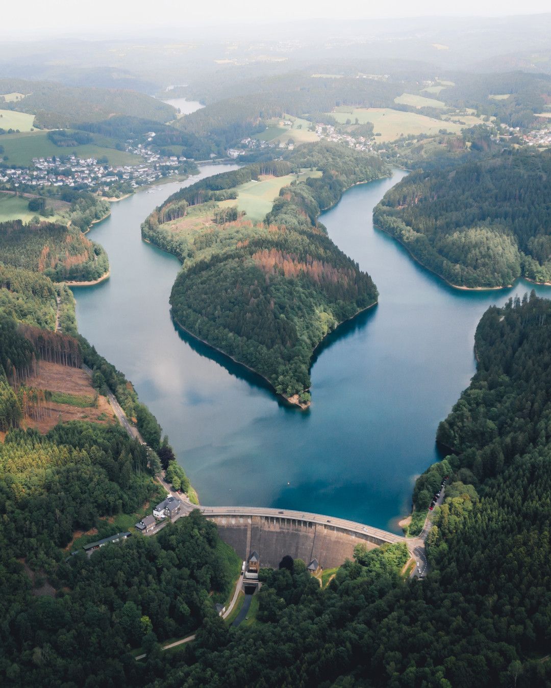 Aerial view of the Aggertal Dam with the surrounding forests and waterways.