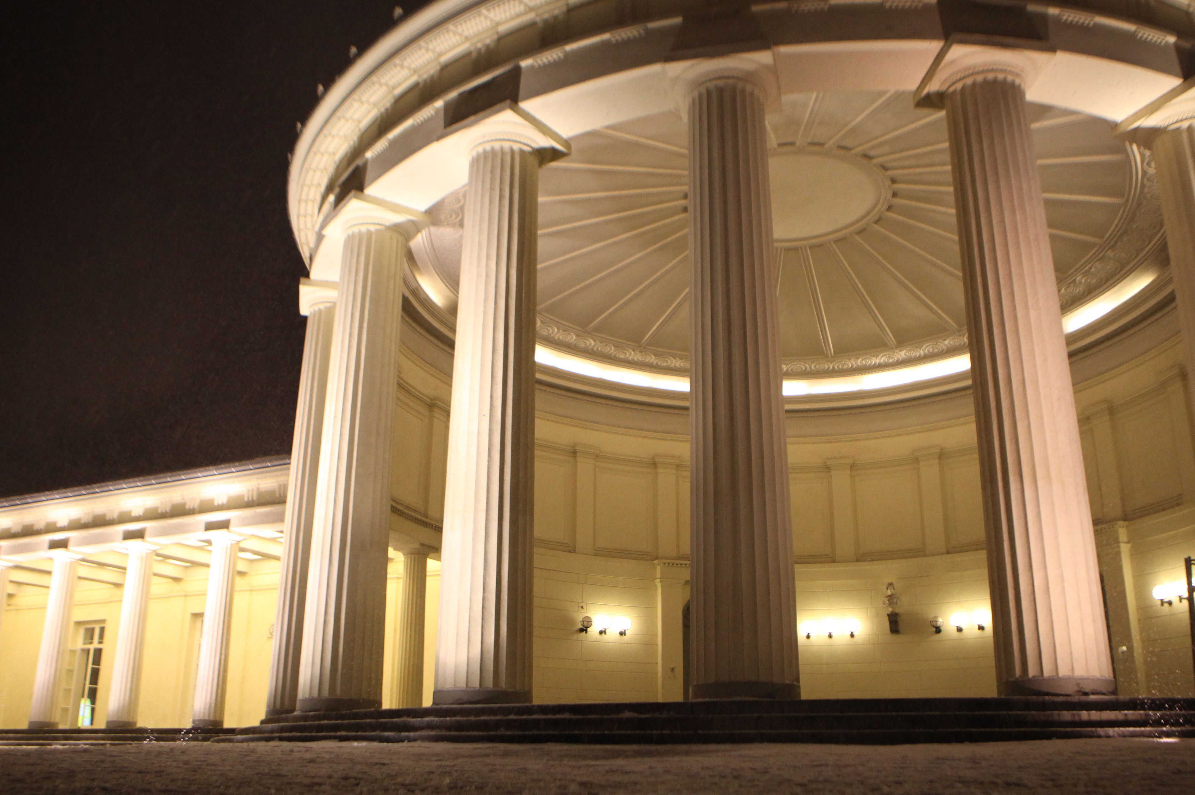 Beleuchtes Brunnenhaus mit weißen Säulen 