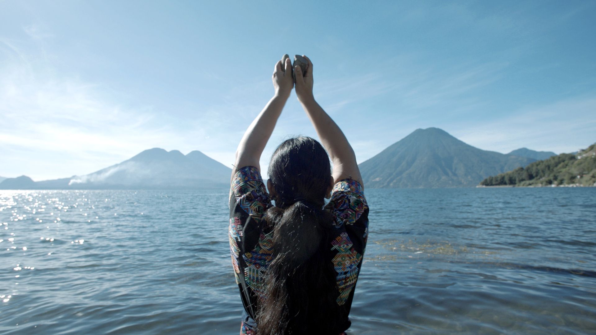 This film still from Clarissa Tossin's "Before the Volcanoes Sing" depicts the ritual connection between indigenous identity and nature at Lake Atitlán in Guatemala