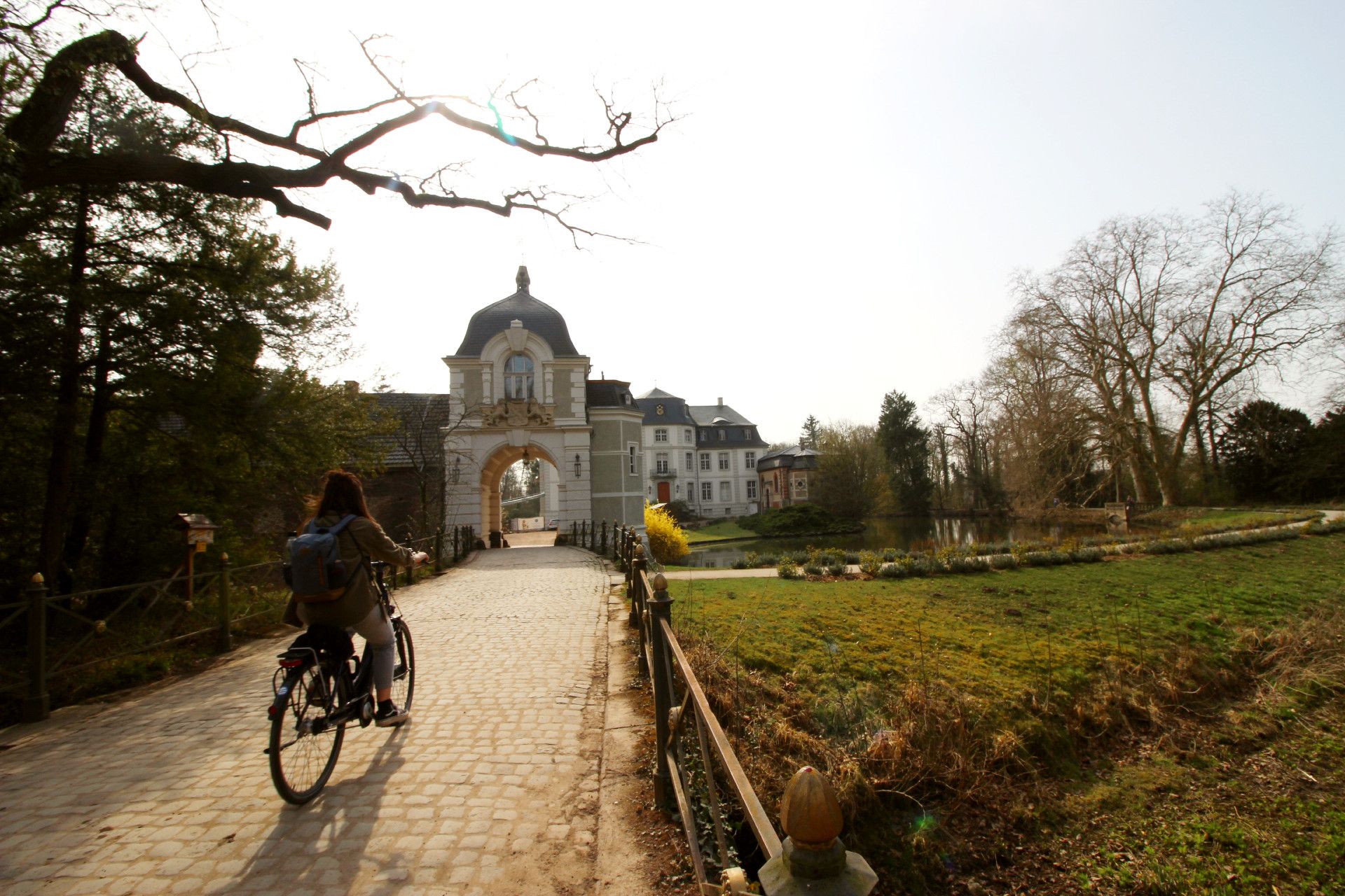 A person on a bicycle rides to Türnich Castle