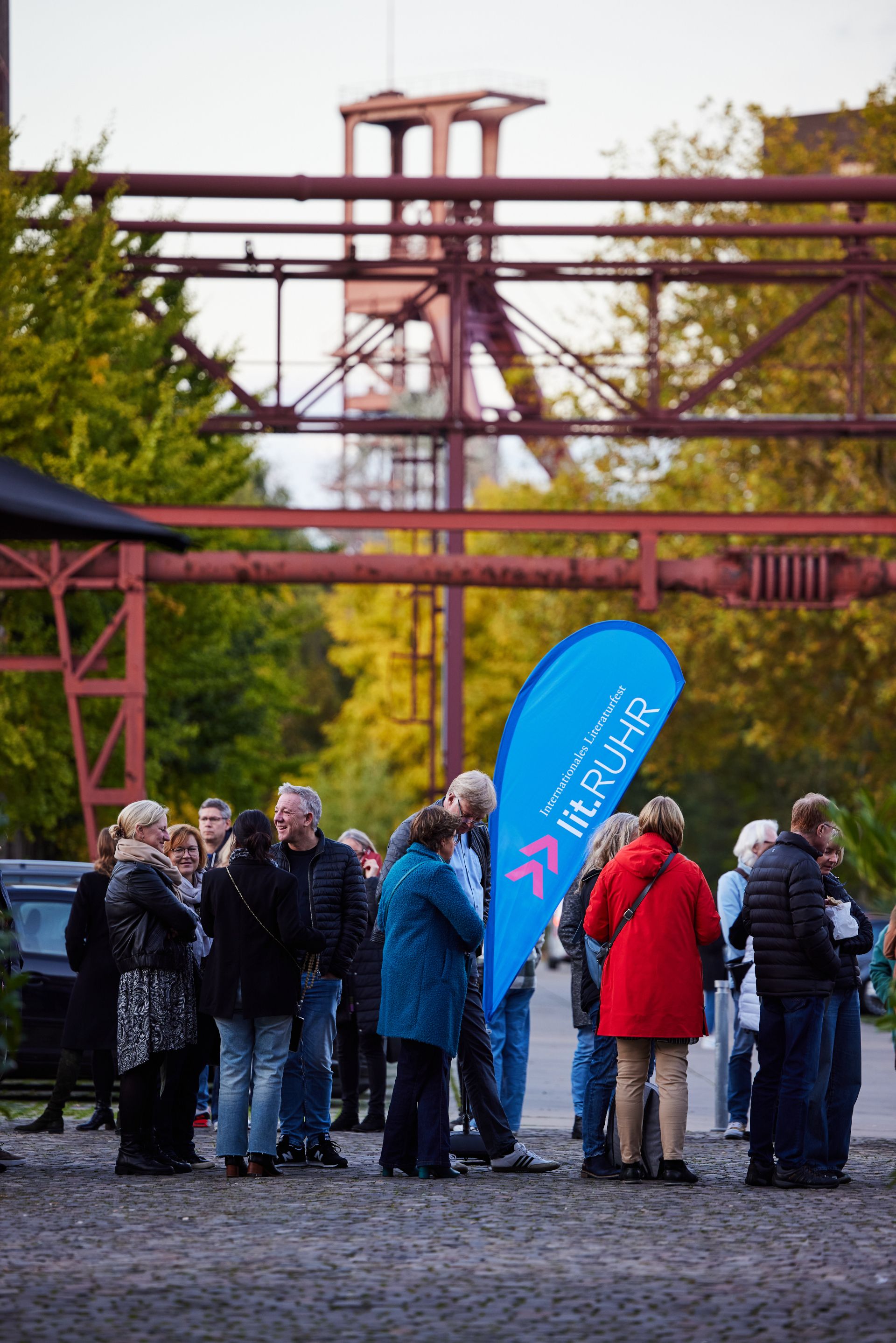 Literature enthusiasts wait in front of the historic industrial buildings at the Zollverein Coal Mine for admission to lit.RUHR