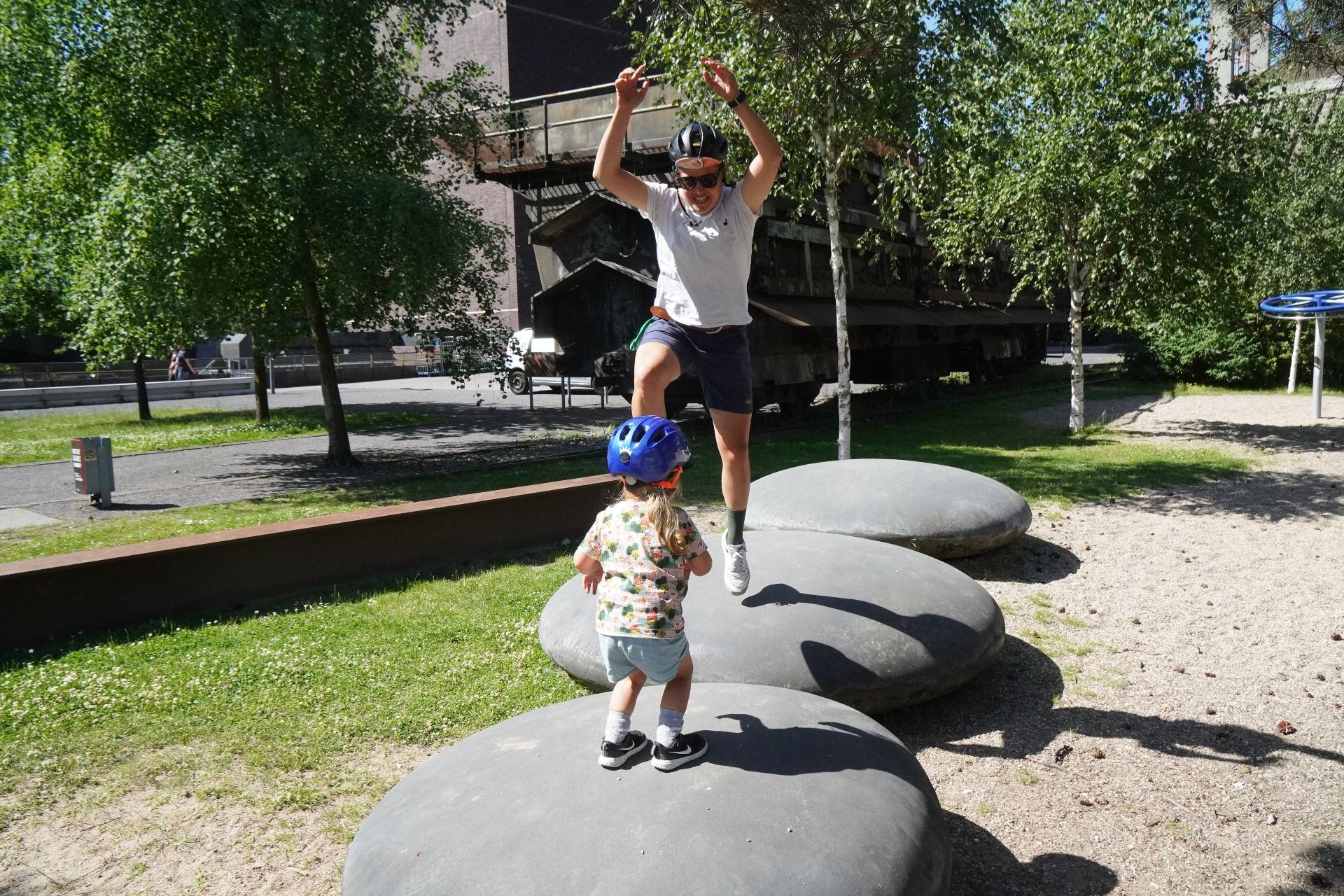 Mother and child jumping on rocks at the Zollverein World Heritage Site in Essen