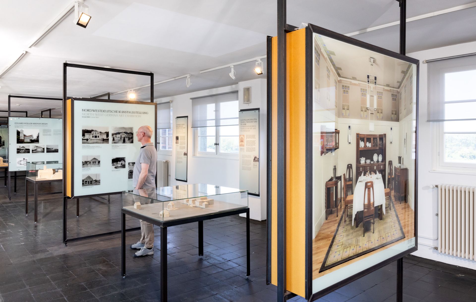 A museum guest looks at showcases in the permanent exhibition in the Peter Behrens Building