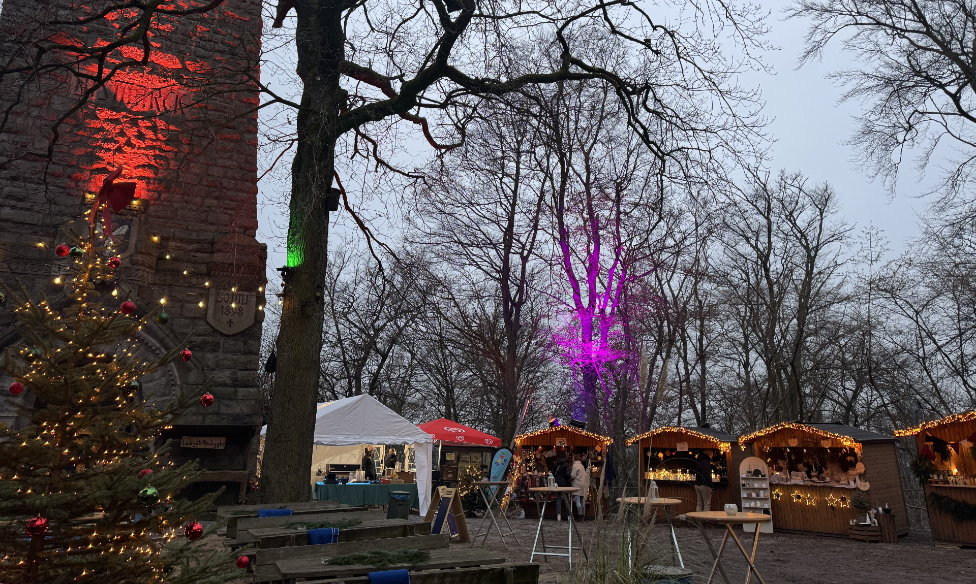 The 3rd winter market at the Bismarck Tower with illuminated stalls and a decorated Christmas tree.