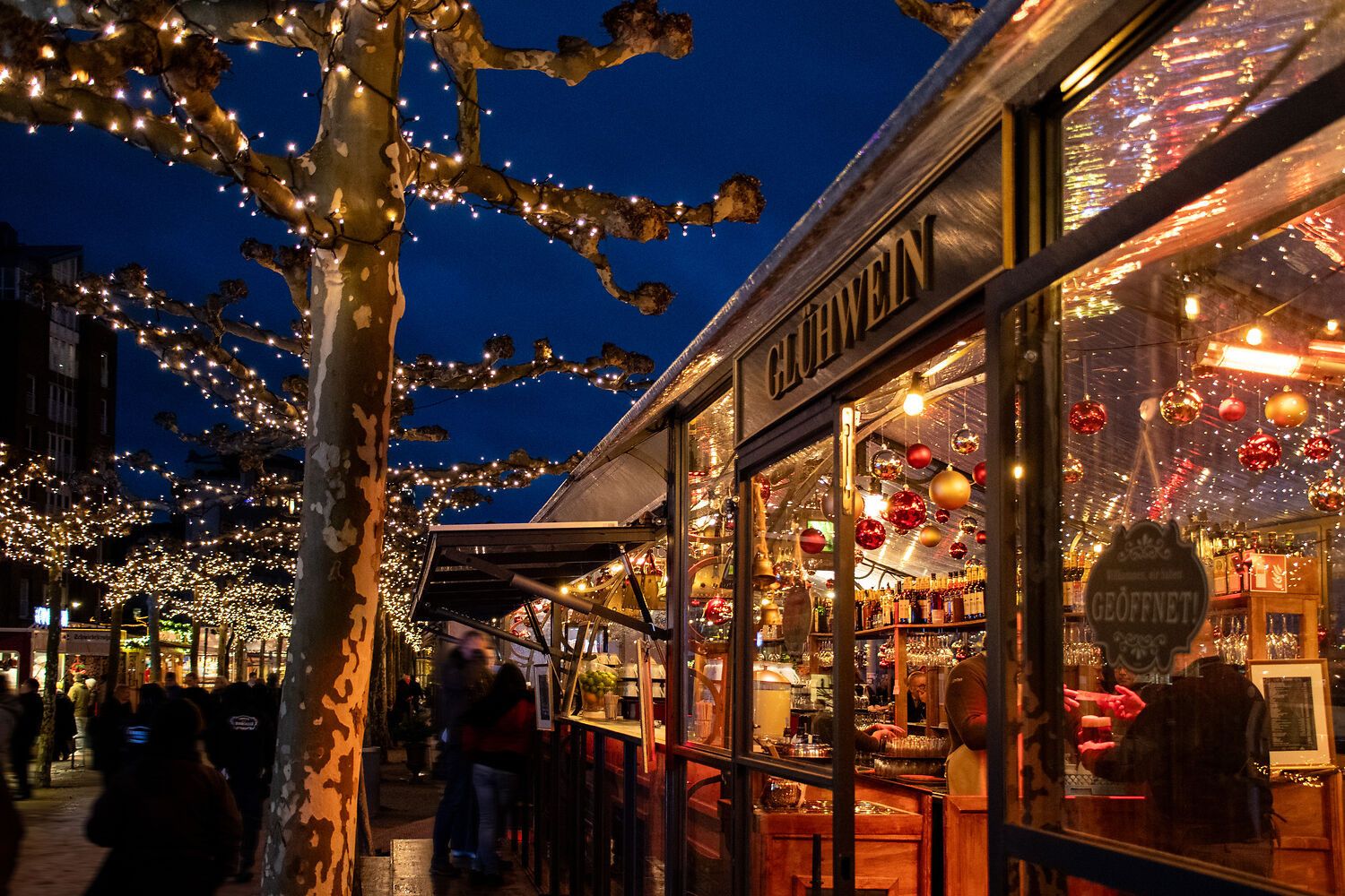 Trees and stalls are decorated with lights on the Christmas promenade in Düsseldorf.