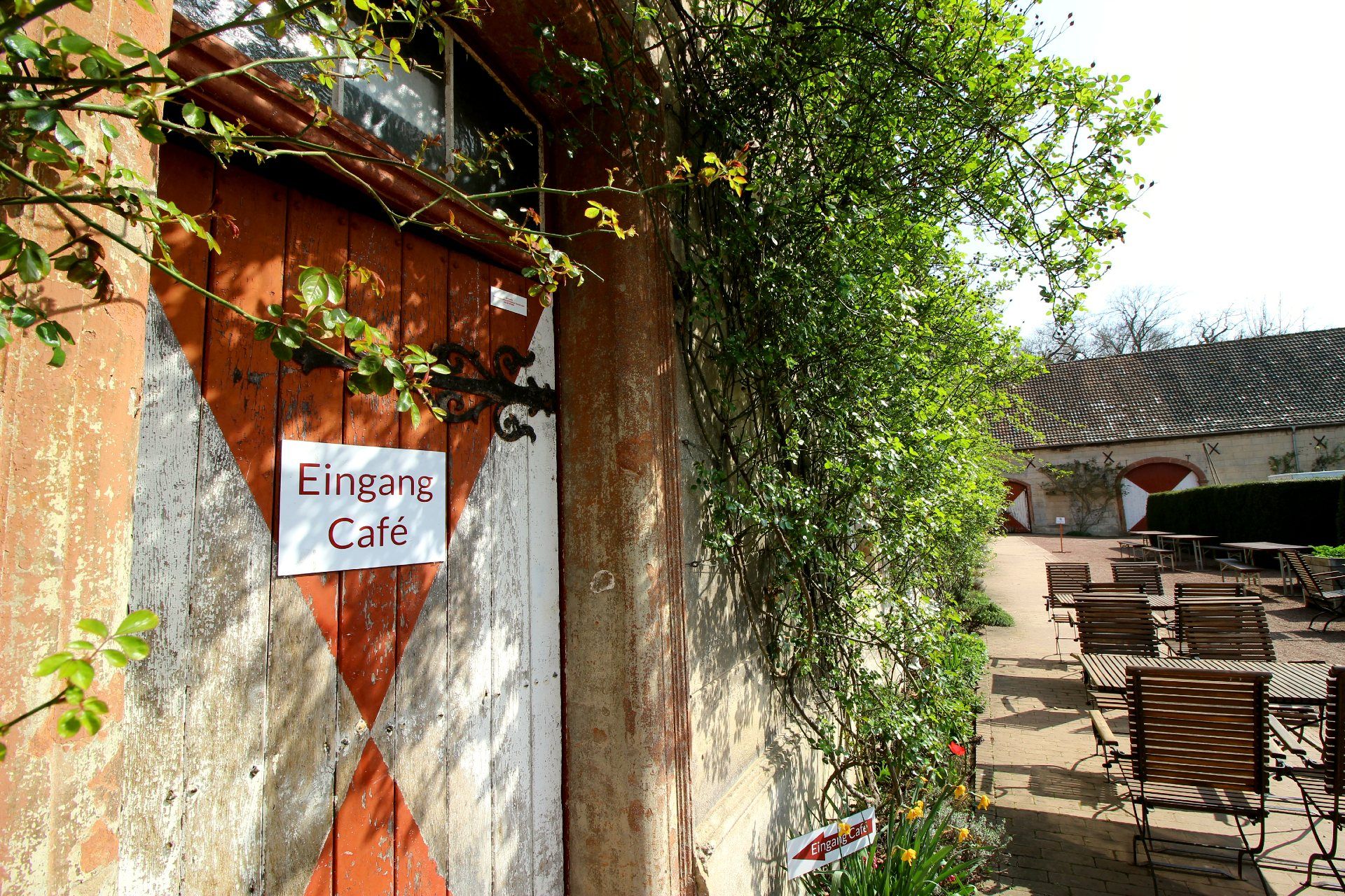 The entrance door, surrounded by plants, leads to a café at Türnich Castle