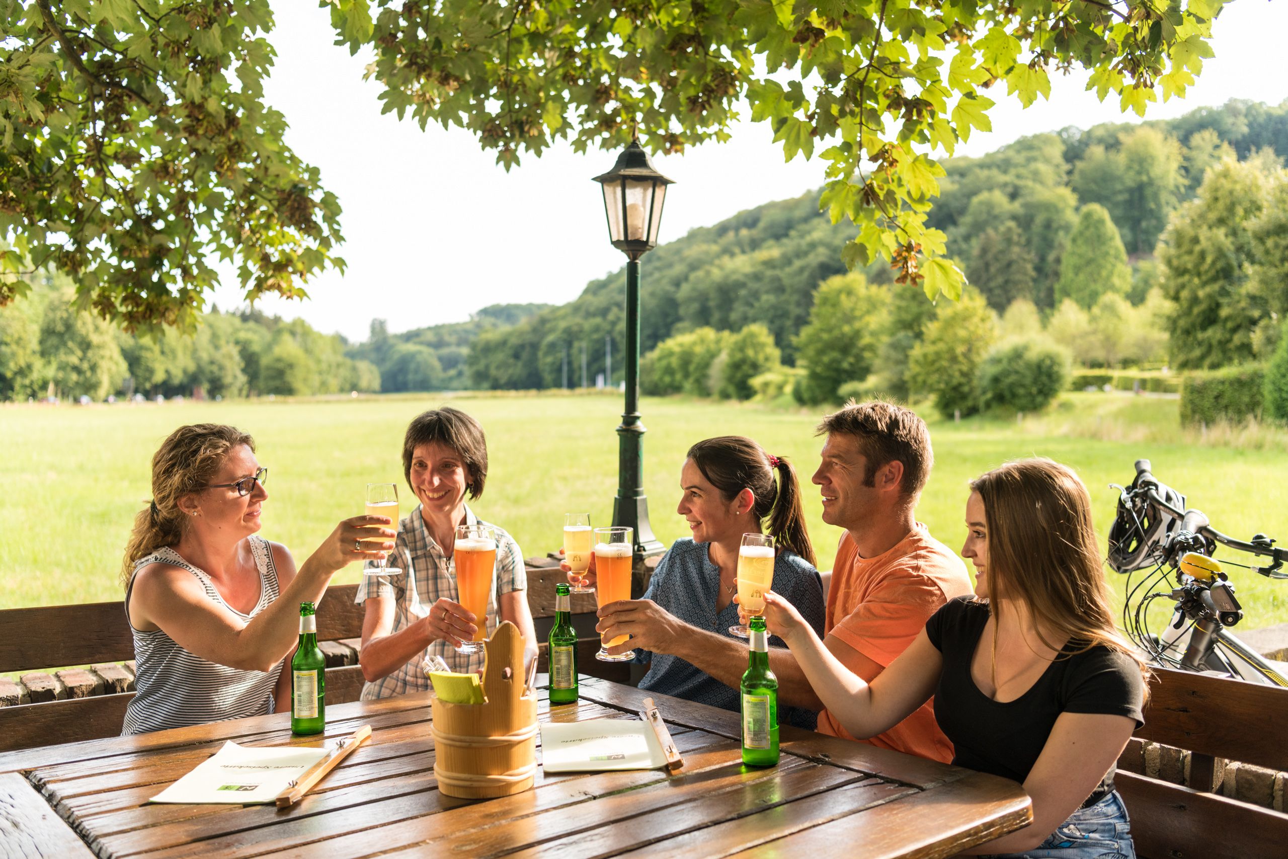 Five people raise their glasses in a beer garden in Odenthal-Altenberg.
