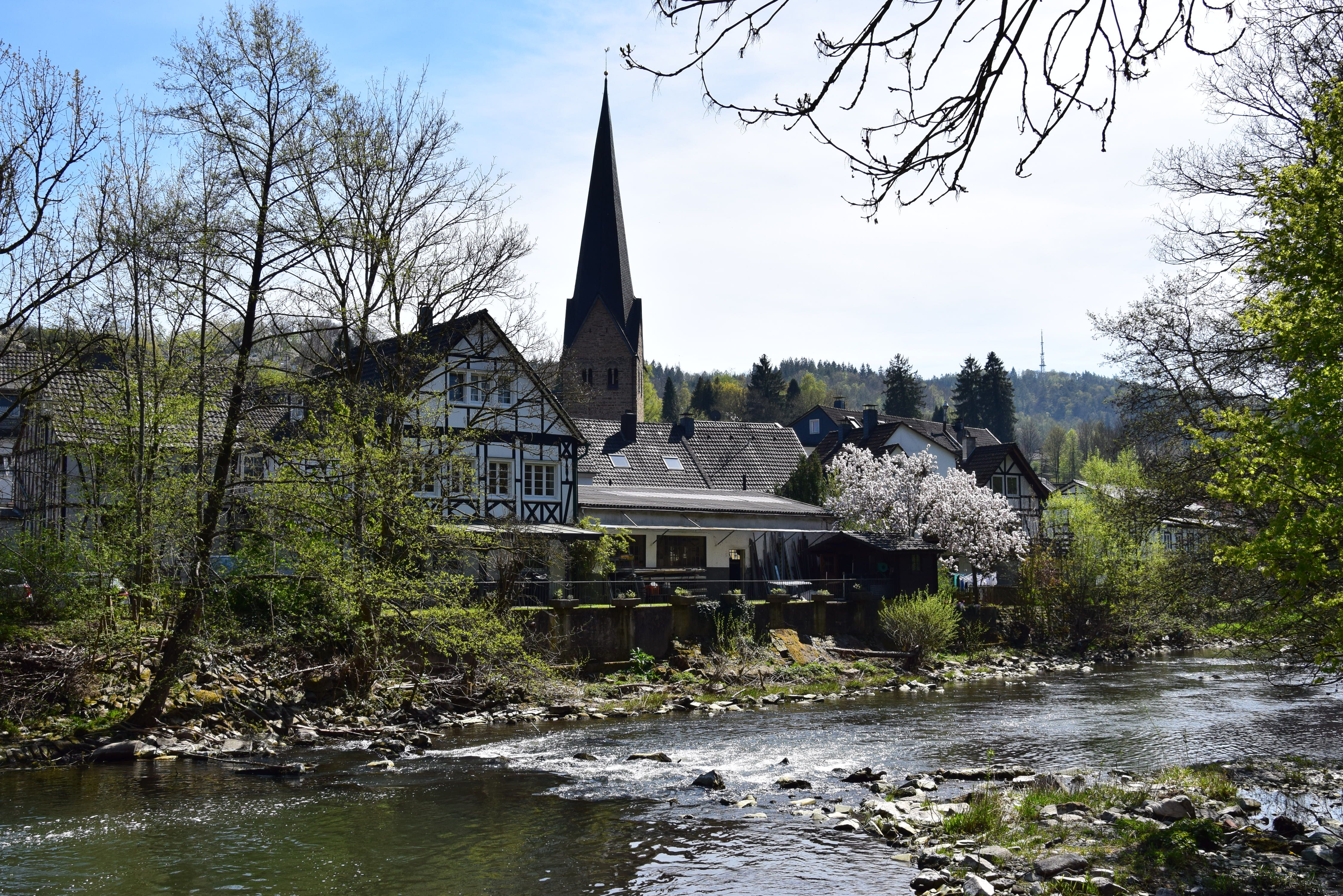 River Agger in Ründeroth, surrounded by half-timbered houses and a church tower.