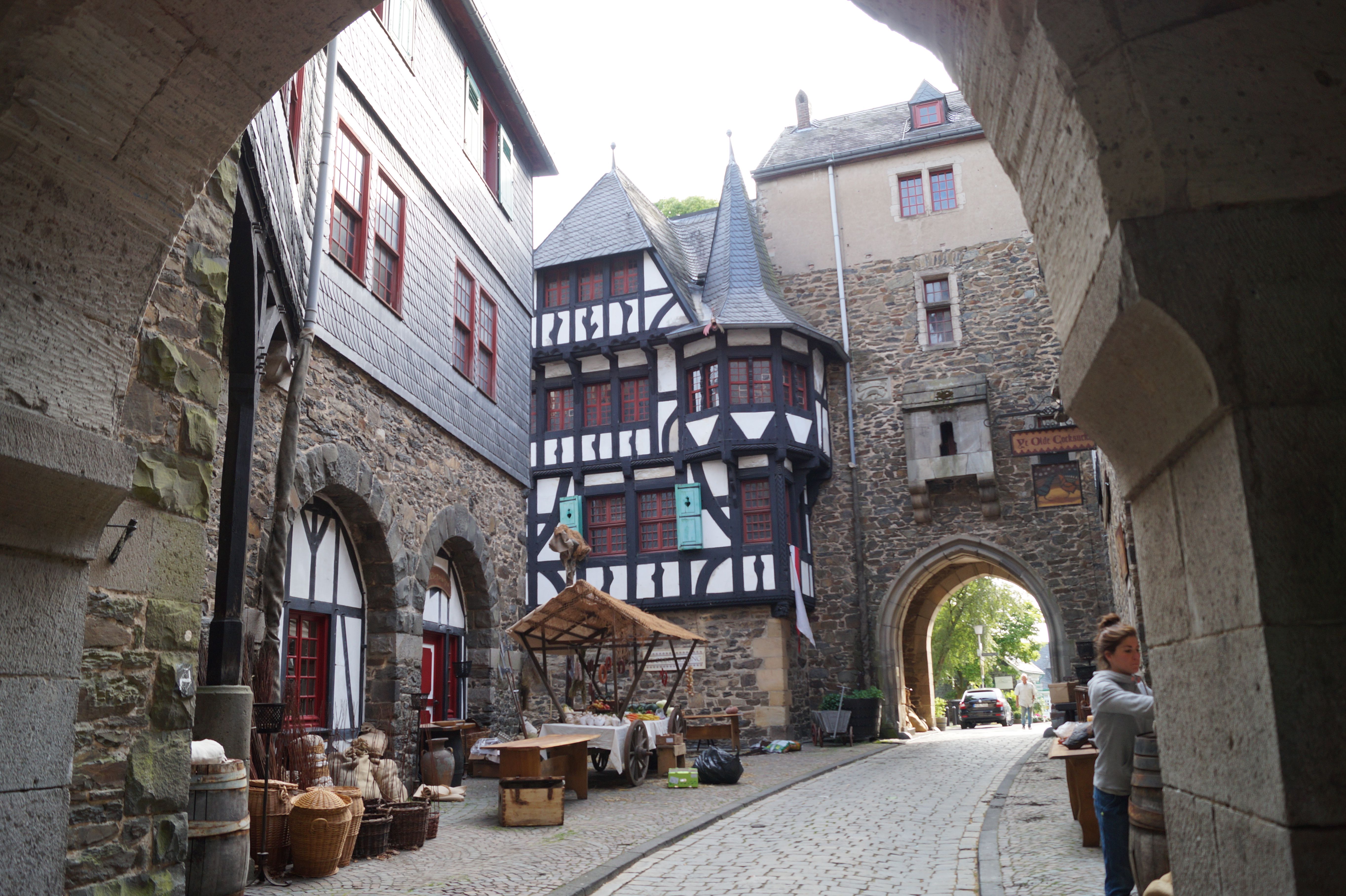 Inner courtyard of Burg Castle with half-timbered building, archway and cobblestones.