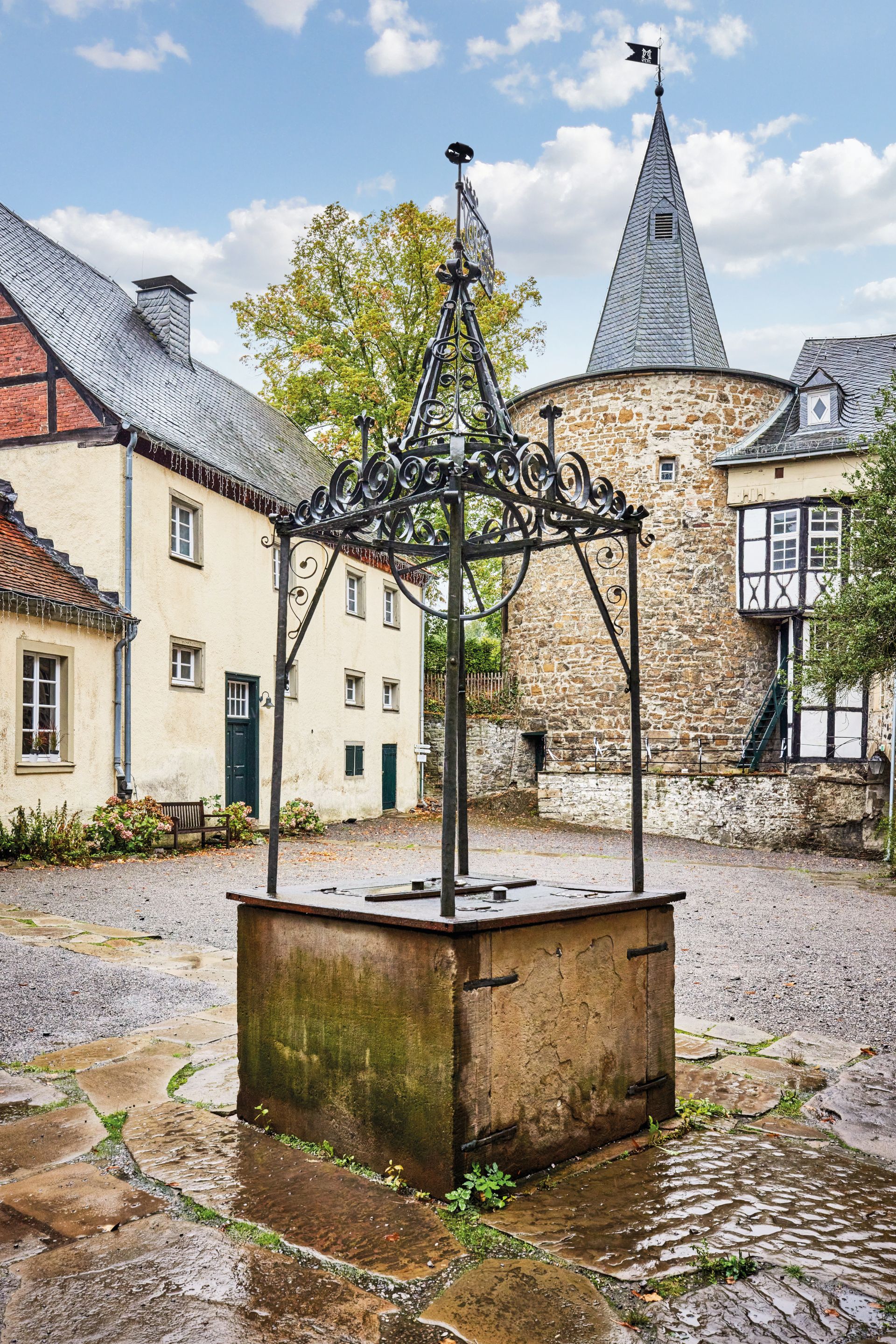 A fountain with a wrought iron top from 1749 stands in the courtyard of Hohenlimburg Castle