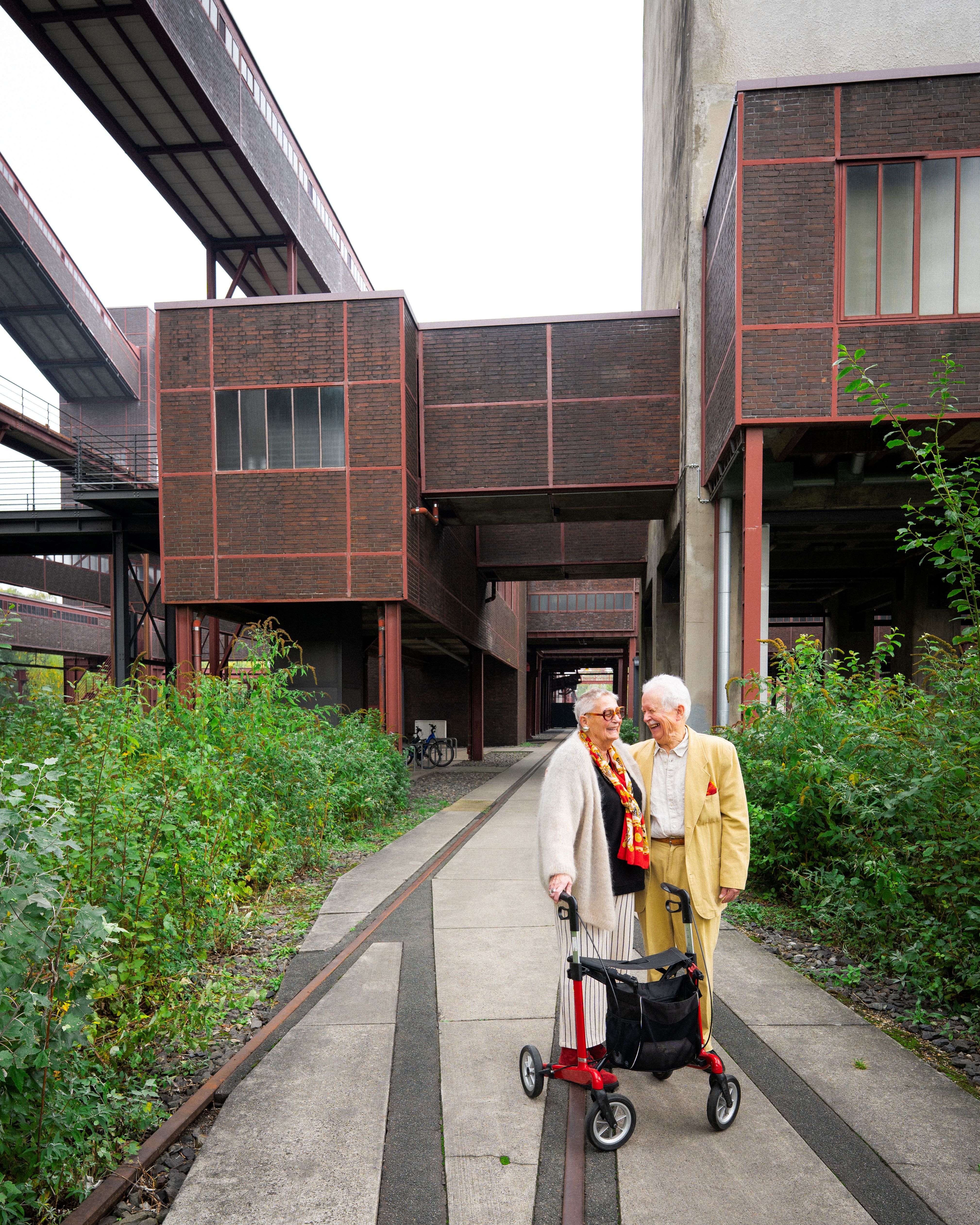 An elderly couple poses for a photo on the grounds of the Zollverein in Essen