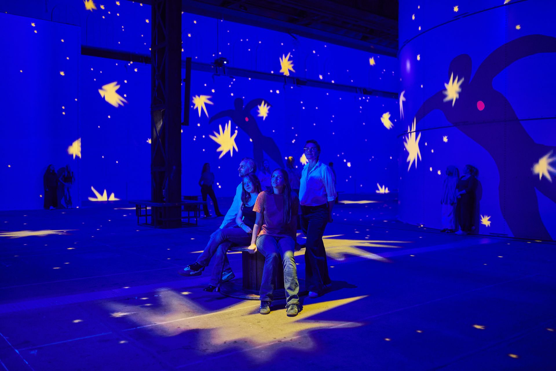 The Blower Hall is transformed into a deep-blue universe of glowing stars and dancing silhouettes from the "Jazz" paper-cut series.