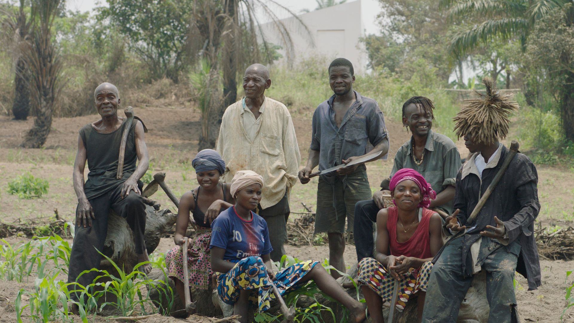 Members of the Artists' Association of Congolese Plantation Workers (CAPTC) in Lusanga, Congo. from left to right: Olele Mulela Mabamba, Irène Kanga, Huguette Kilembi, Jérémie Mabiala, Jean Kawata, Mbuku Kimpala, Ced'art Tamasala and Matthieu Kasiama. In the background the exhibition space White Cube