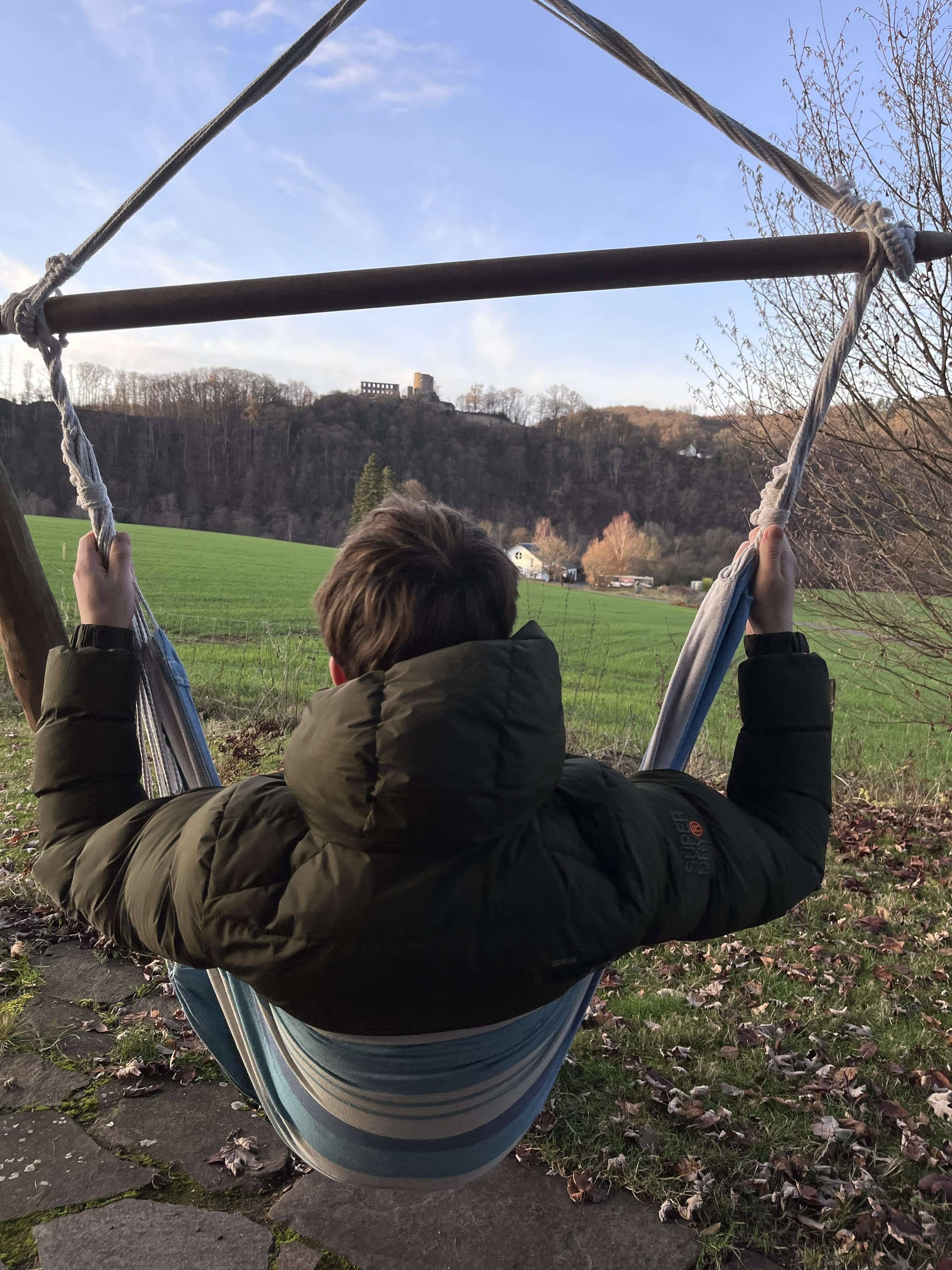 Silke Dames, Tourismus NRW e.V., Hängematte am Baumhaus mit Blick auf Burgruine Windeck
