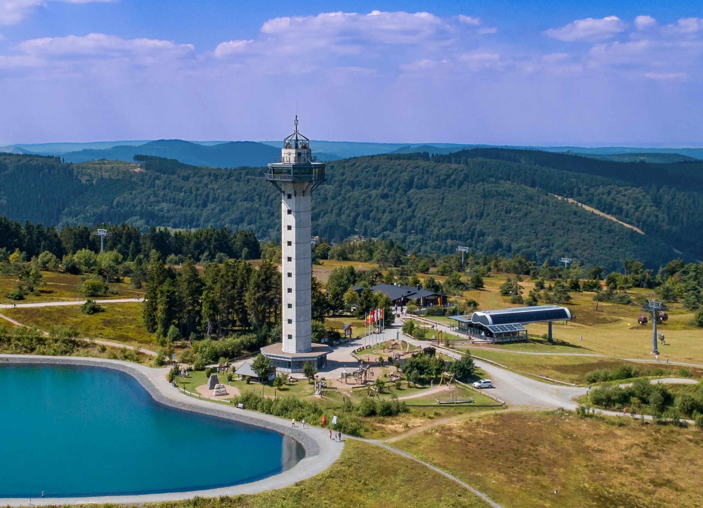 High heath tower on the Ettelsberg in Willingen, surrounded by forest and a mountain lake.