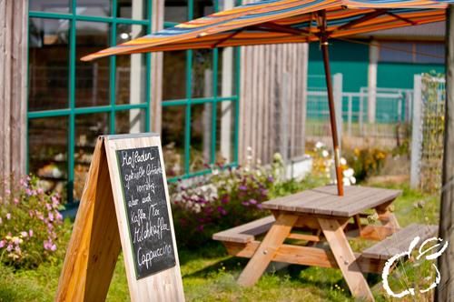The farm store team announces current offers and special delicacies on a board in front of the entrance