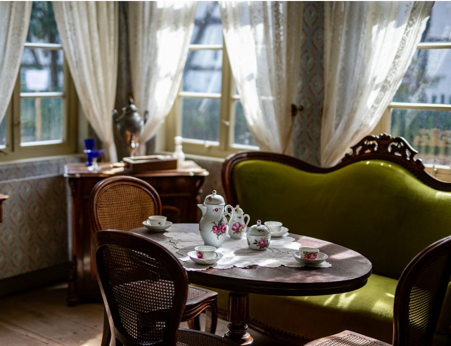 Table set for dining surrounded by chairs and a sofa