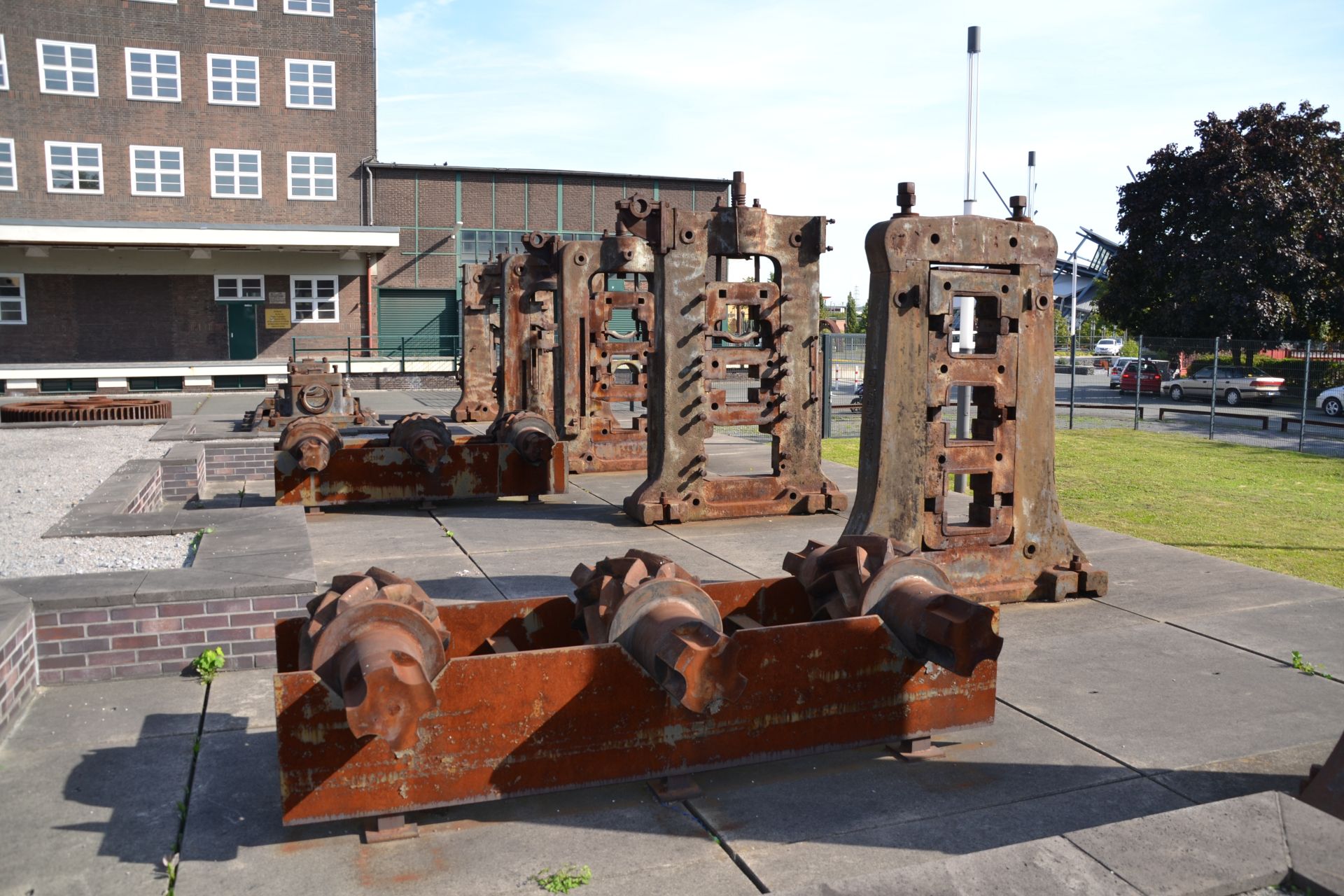 On the grounds of the Peter Behrens Building, historical machines convey individual work processes in heavy industry
