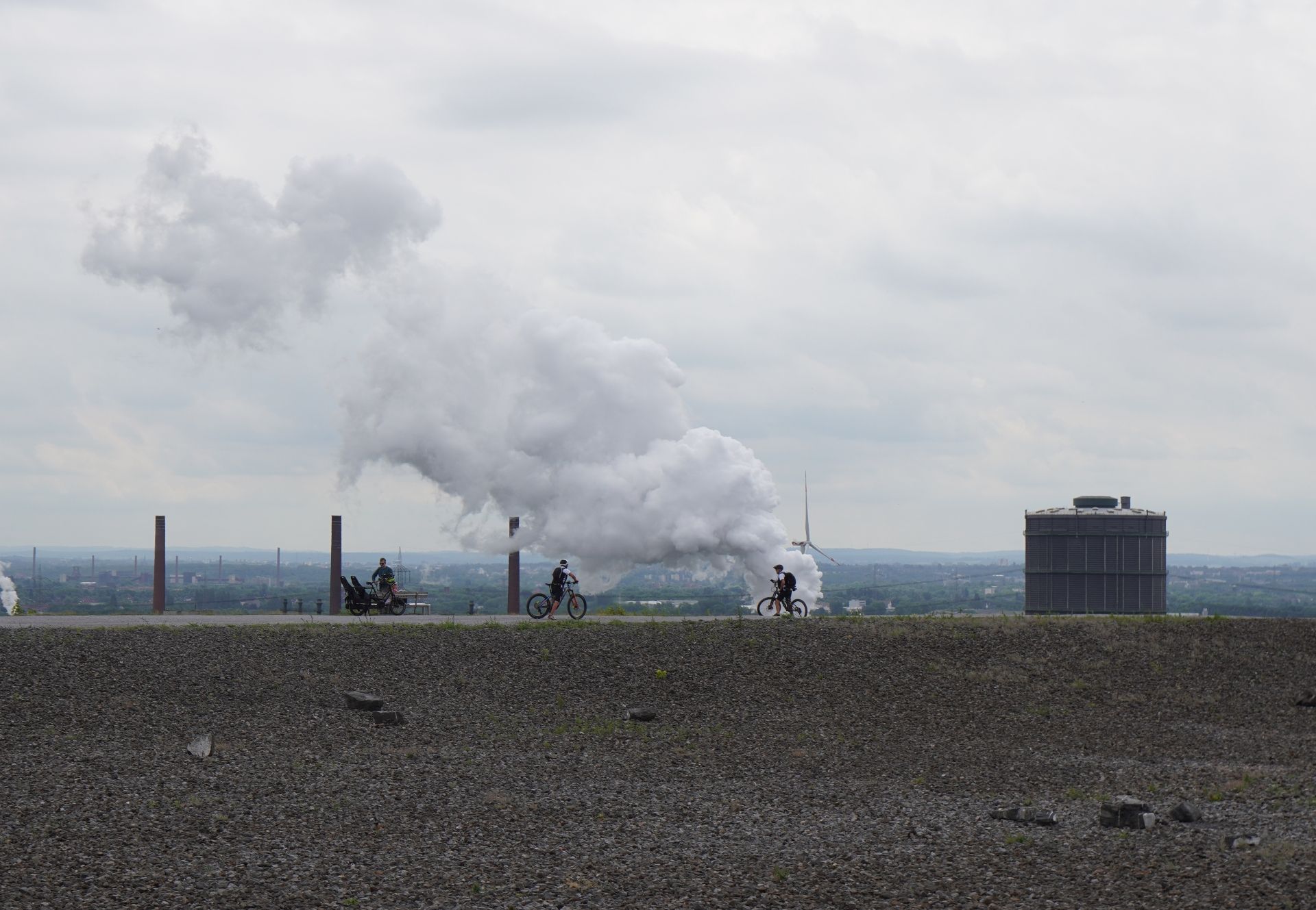 Cyclists ride on the Halde Beckstraße in Bottrop, with the Gasometer visible in the background