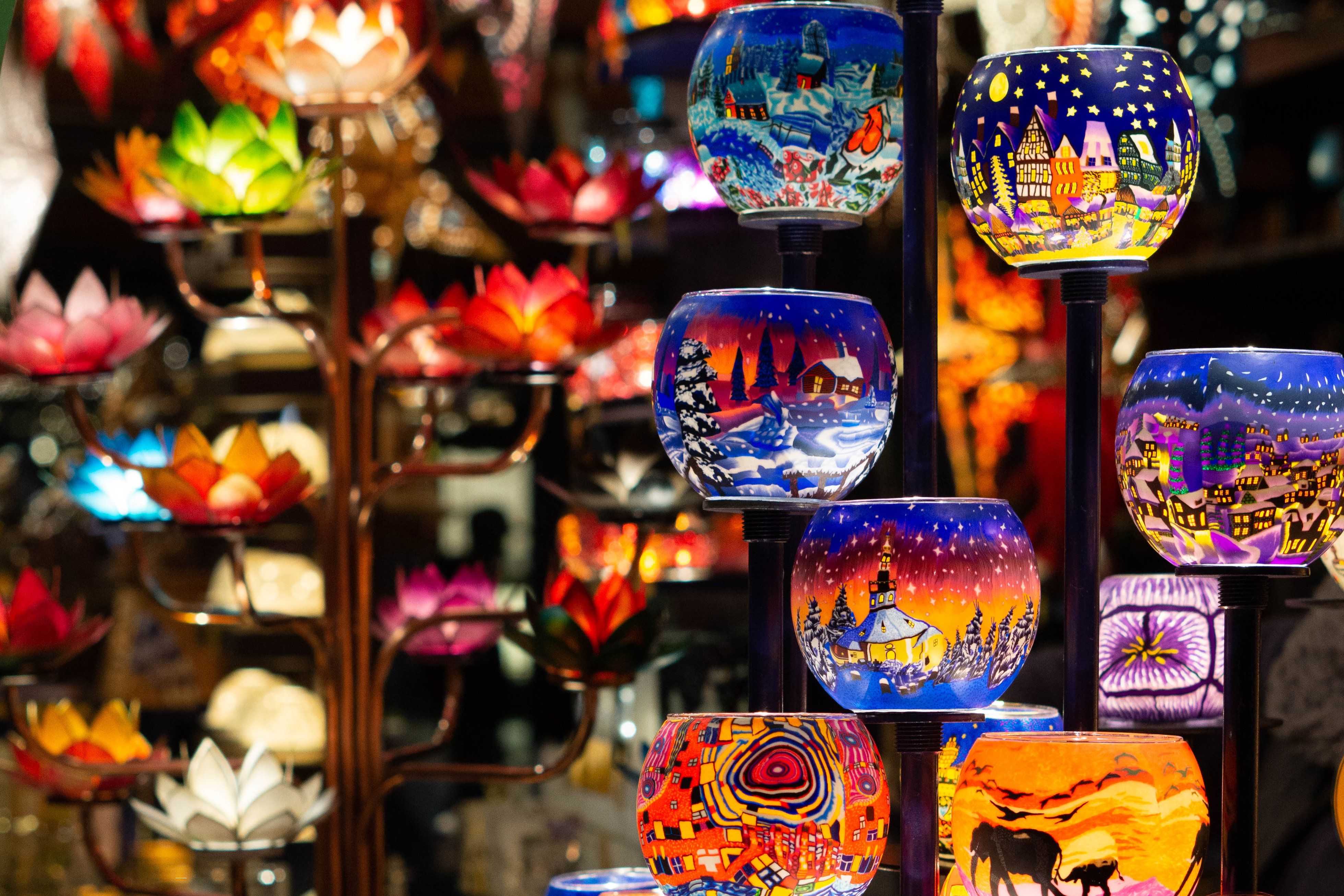 Colorful, hand-painted candle holders with winter and urban motifs at the Duisburg Christmas market.