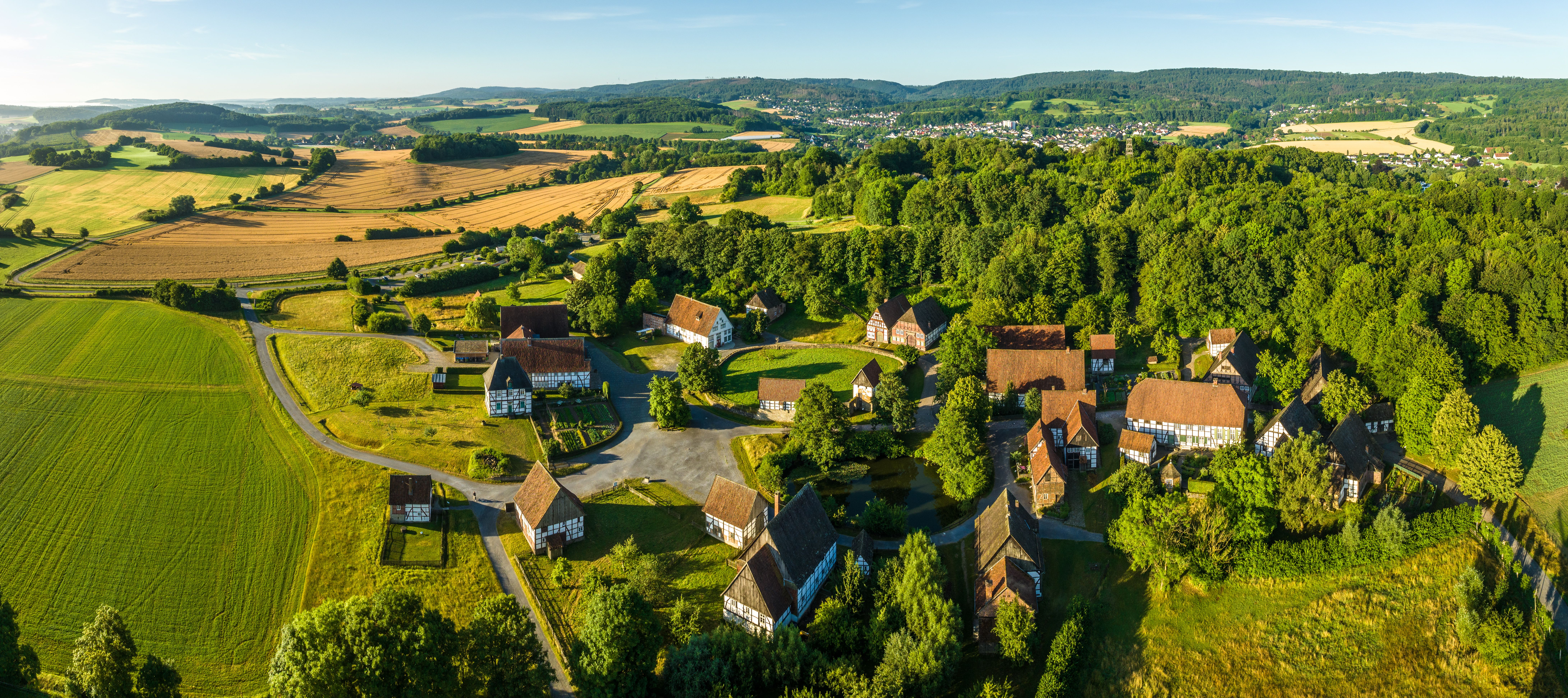 A bird's-eye view of the Detmold Open-Air Museum, surrounded by lush greenery.