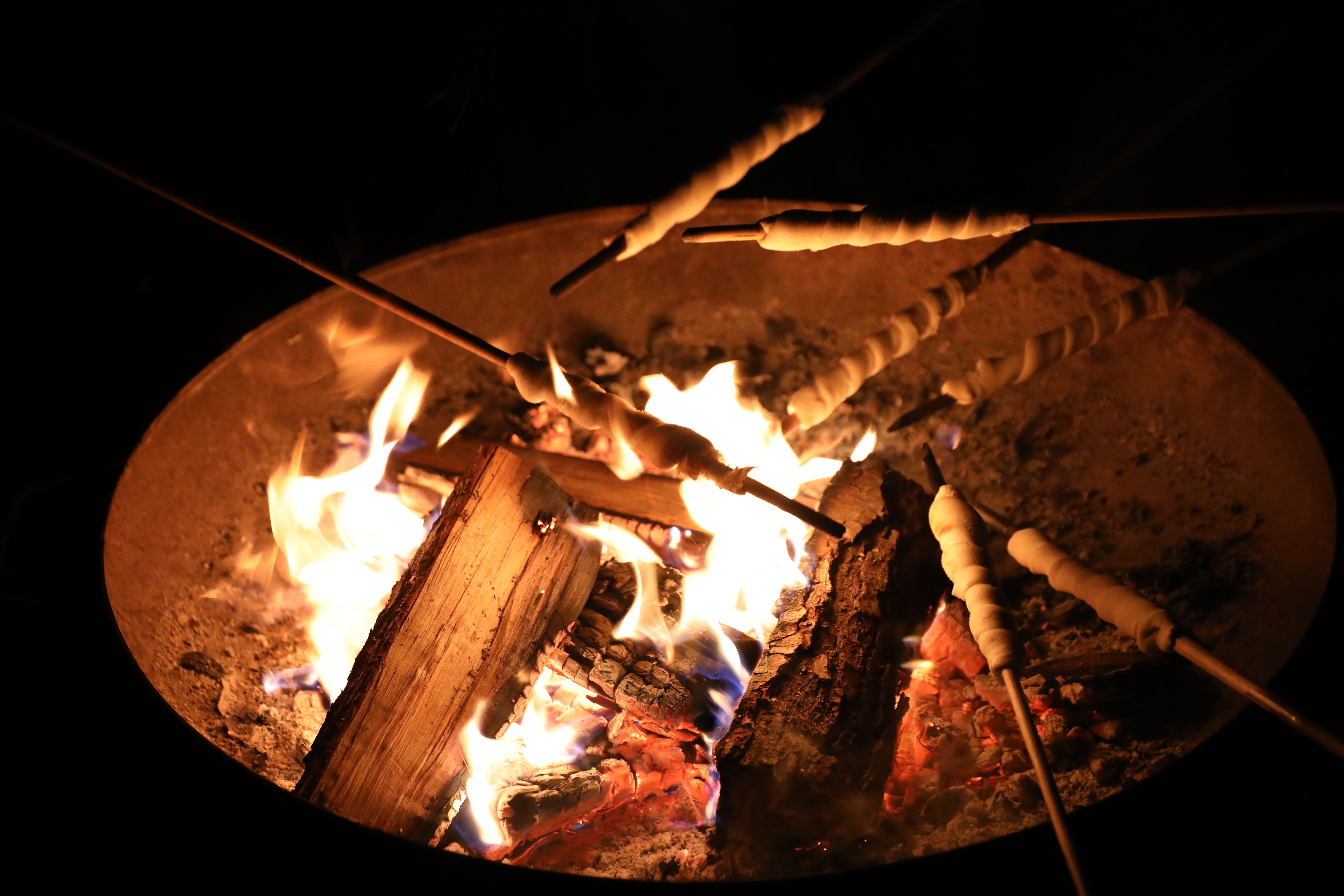 Stick bread is roasted over a campfire at the Christmas market at Eulenbroich Castle.