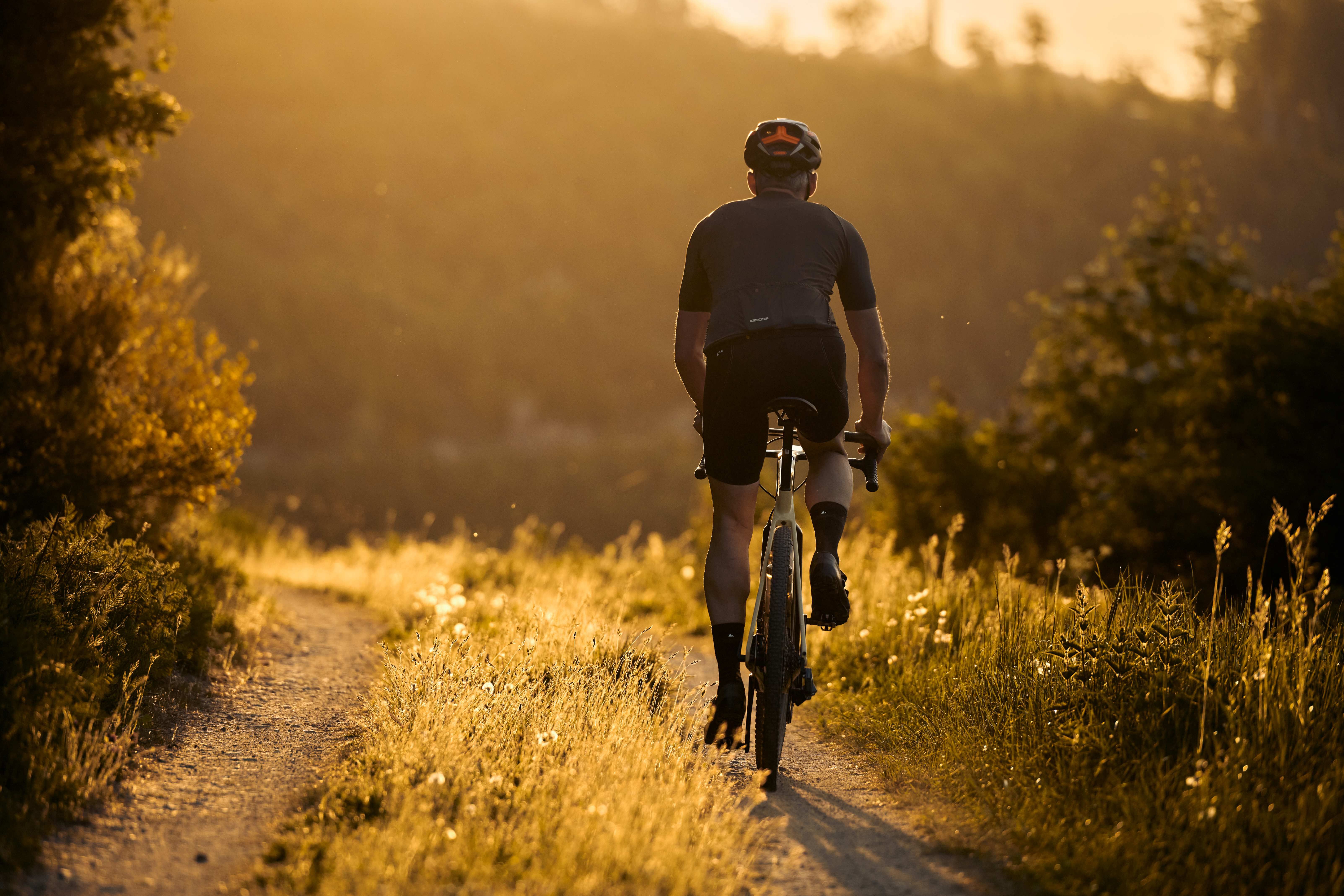 Two people are riding gravel bikes on an unpaved forest path in the Sauerland.