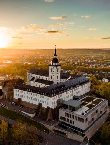 Aerial view of Siegburg: Michaelsberg with the KSI at sunset and a view over the city.