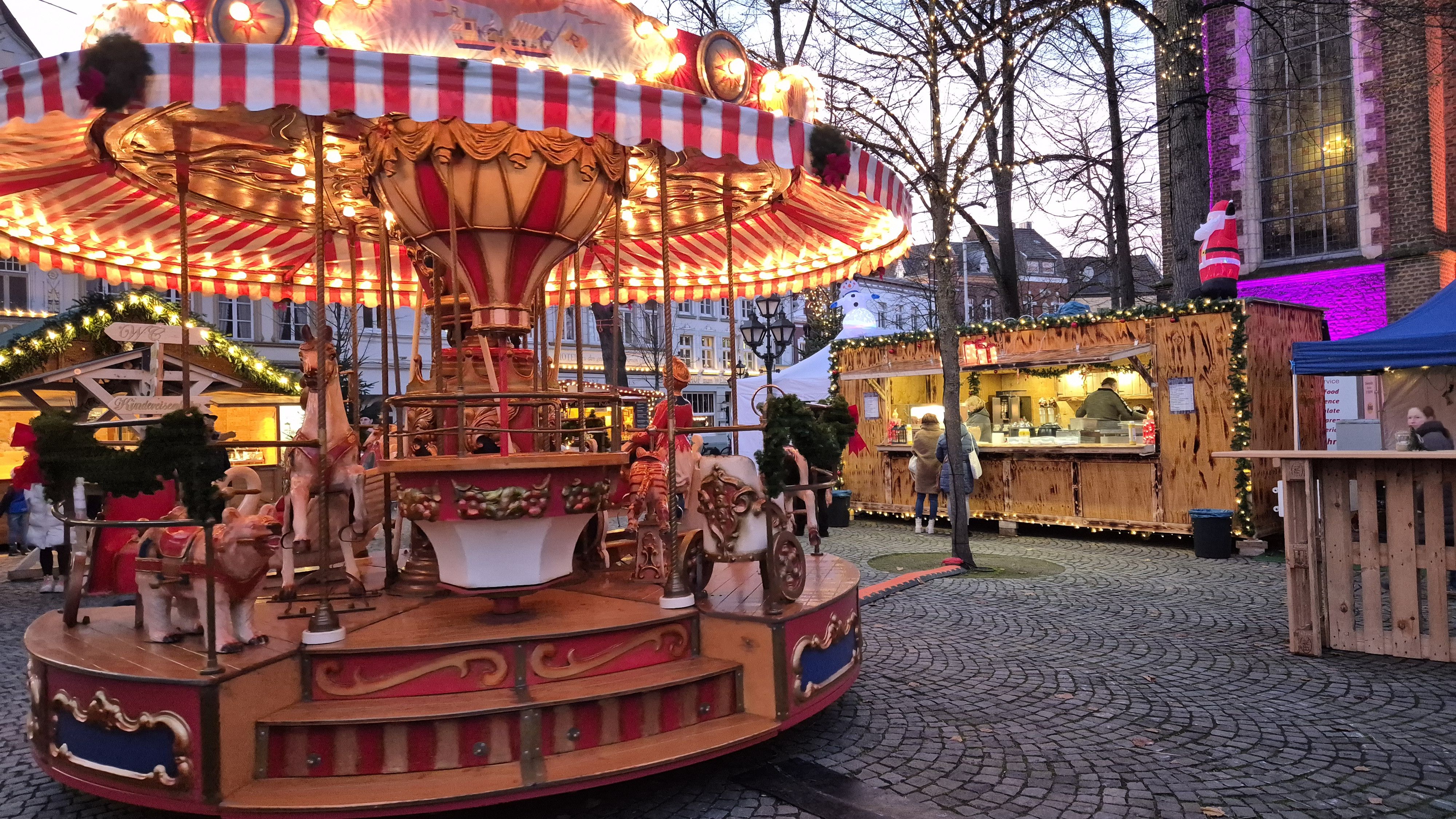 An illuminated carousel with horses can be found at the Kevelaerer Krippenmarkt.