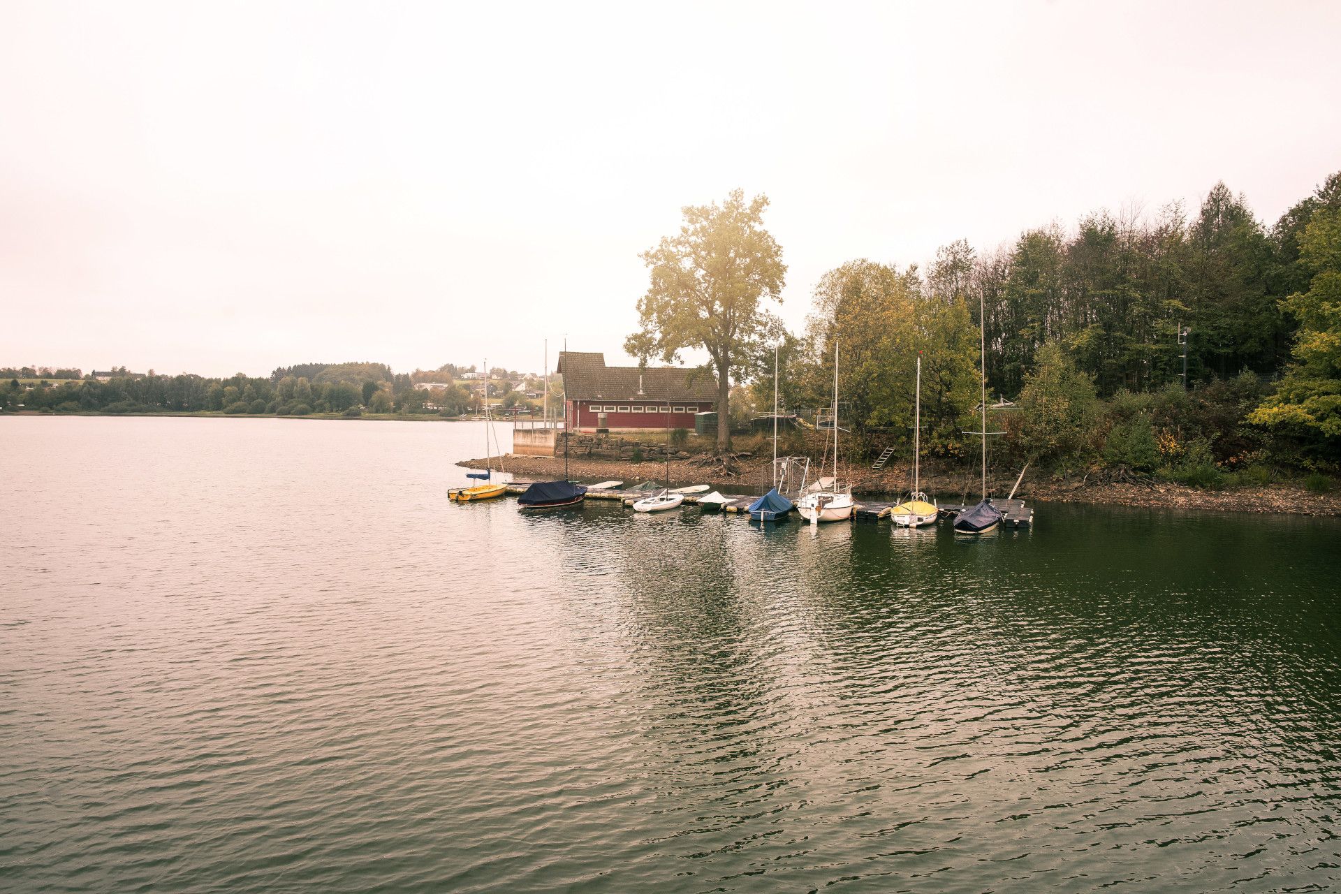 Sailing boats and wooden house at the Bruchertalsperre dam