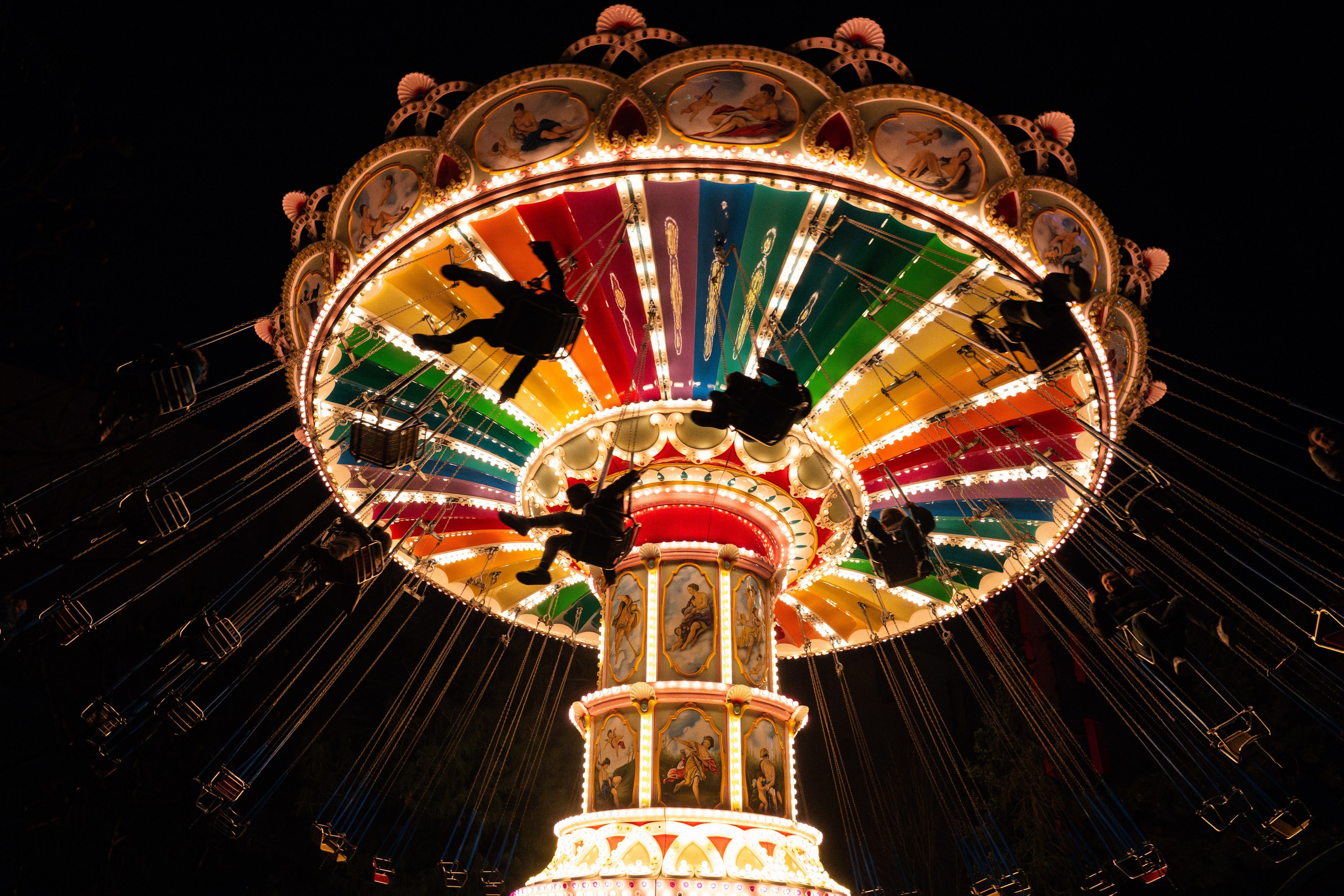 A colorfully illuminated chain carousel turns at night in Wunderland Kalkar.