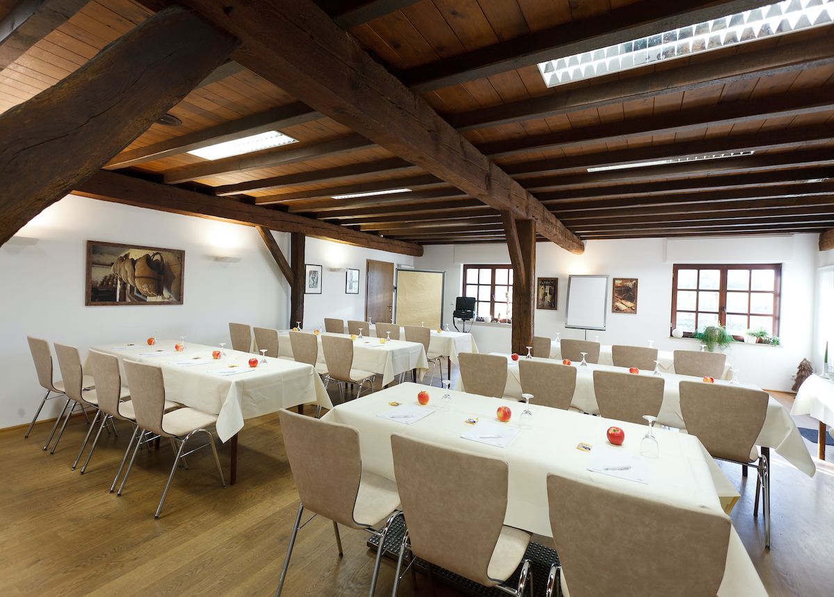 A clog room in Kalkar with wooden beam ceilings, tables and chairs, decorated with apples and wine glasses.
