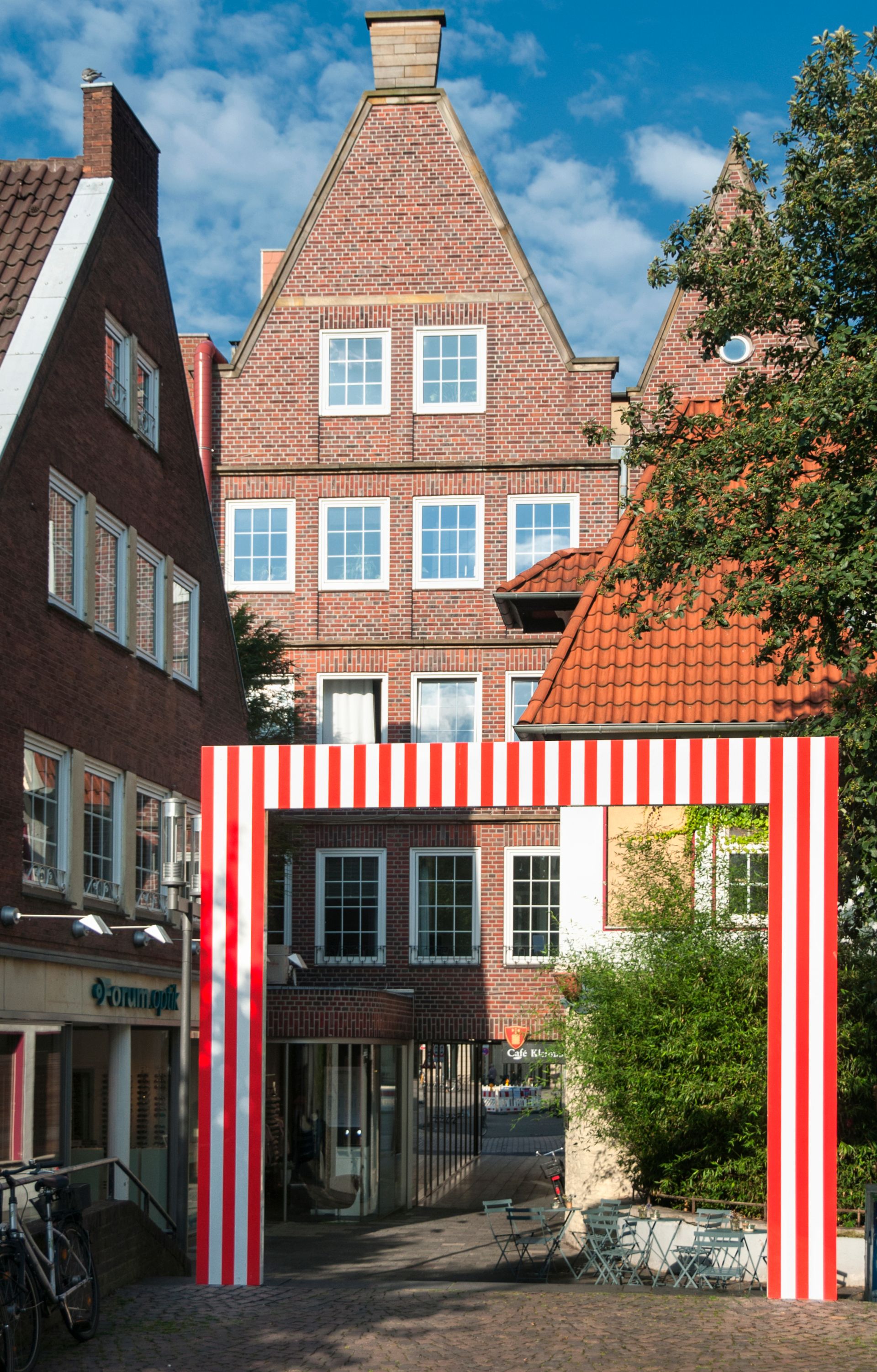The red and white gate by French artist Daniel Buren marks the historic transition from the cathedral's freedom to the city. The contribution to the 1987 sculpture projects at the time comprised four gates