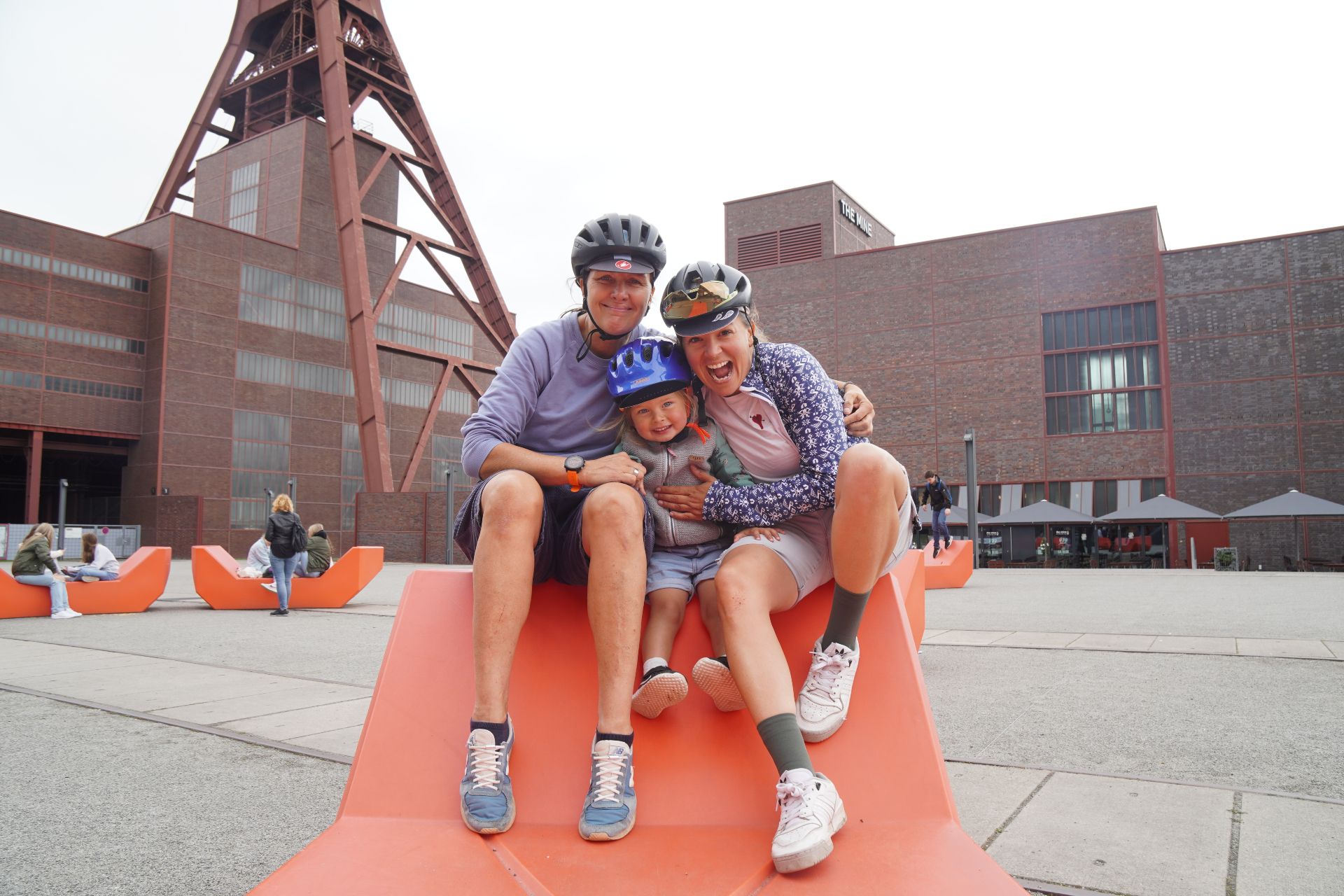 A family sits in front of the Zollverein World Heritage Site in Essen
