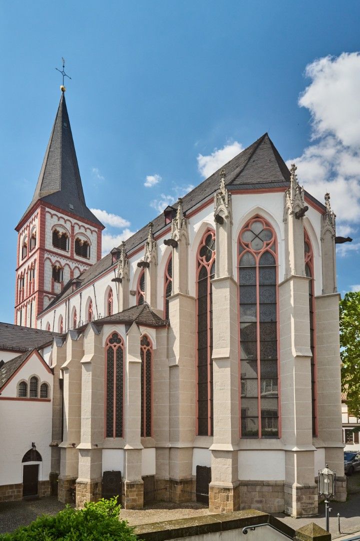 St. Servatius Church in Siegburg: a Gothic church with a tall tower and large tracery windows under a blue sky.