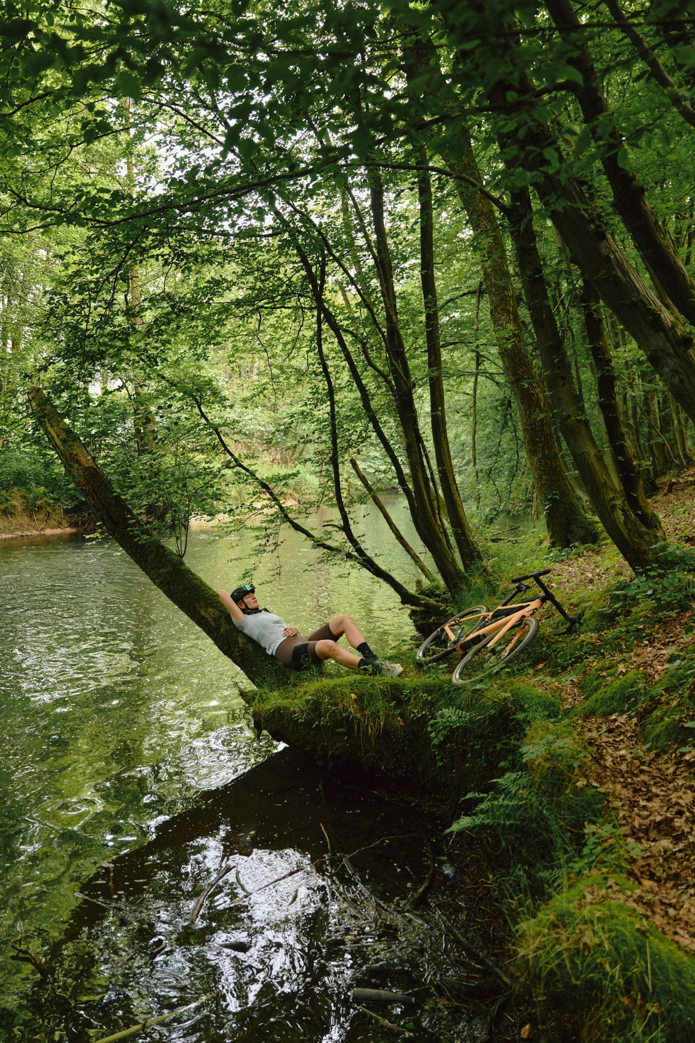 Taking a break on a log by the riverbank in the forest.