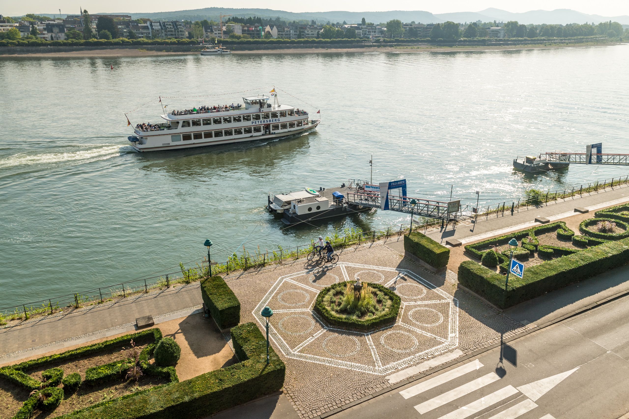 Two cyclists are riding along the Rhine.