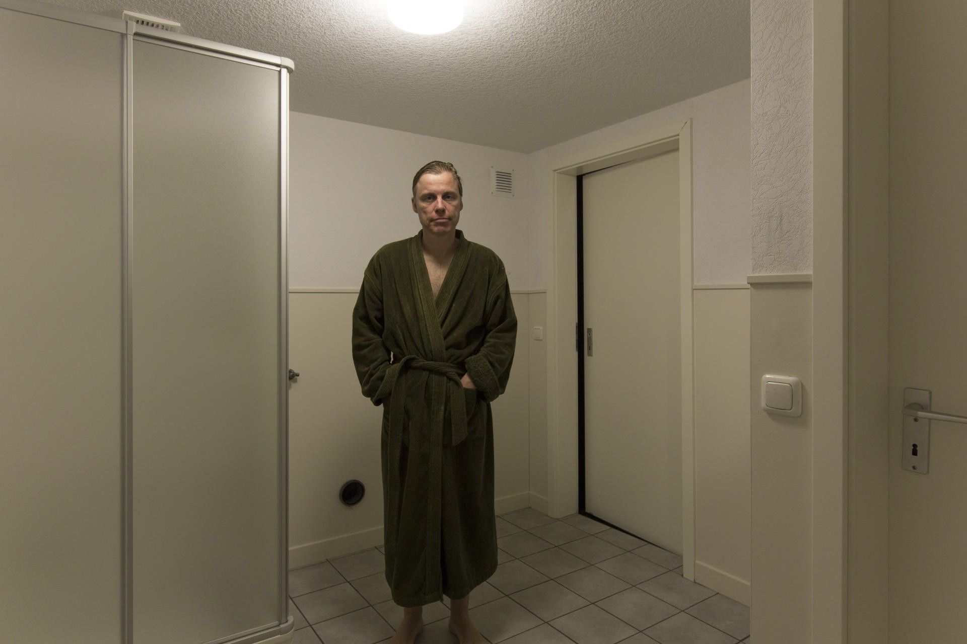 Self-portrait in the oppressive atmosphere of a sterile bathroom from the "Neuburgerstraße 21" project in an old industrial hall at the Schauspiel Köln