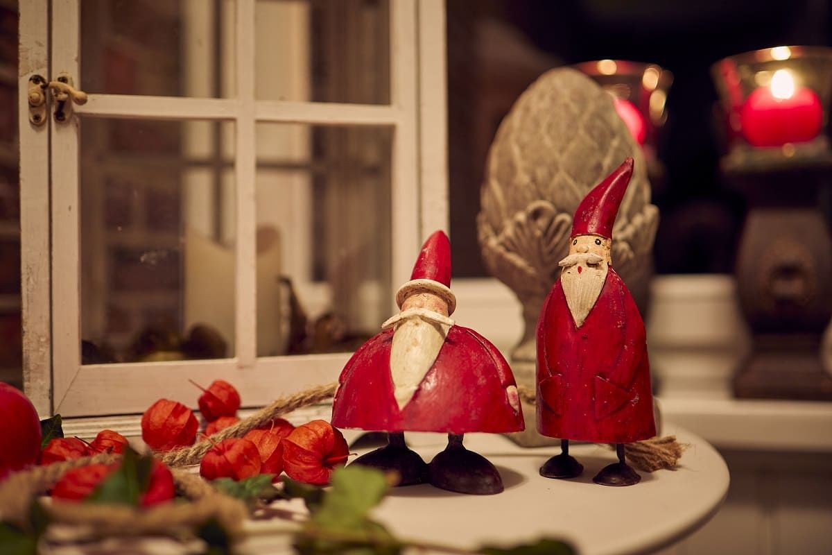 Two red wooden Santa Claus figures stand on a table.