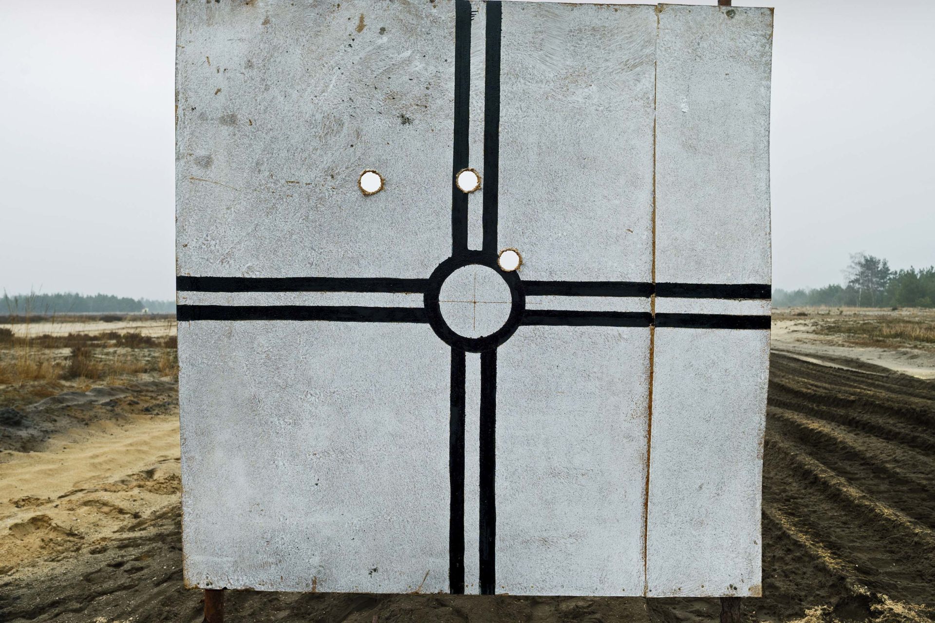 In *Mit dem Fadenkreuz*, Herlinde Koelbl combines her personal experience with her earlier photographic exploration of military shooting targets